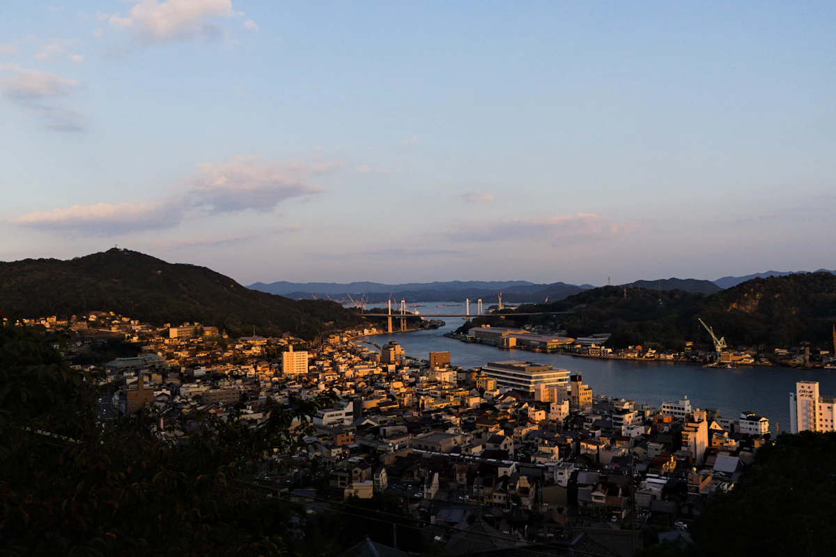 A coastal Japanese town overlooking a bay at sunset
