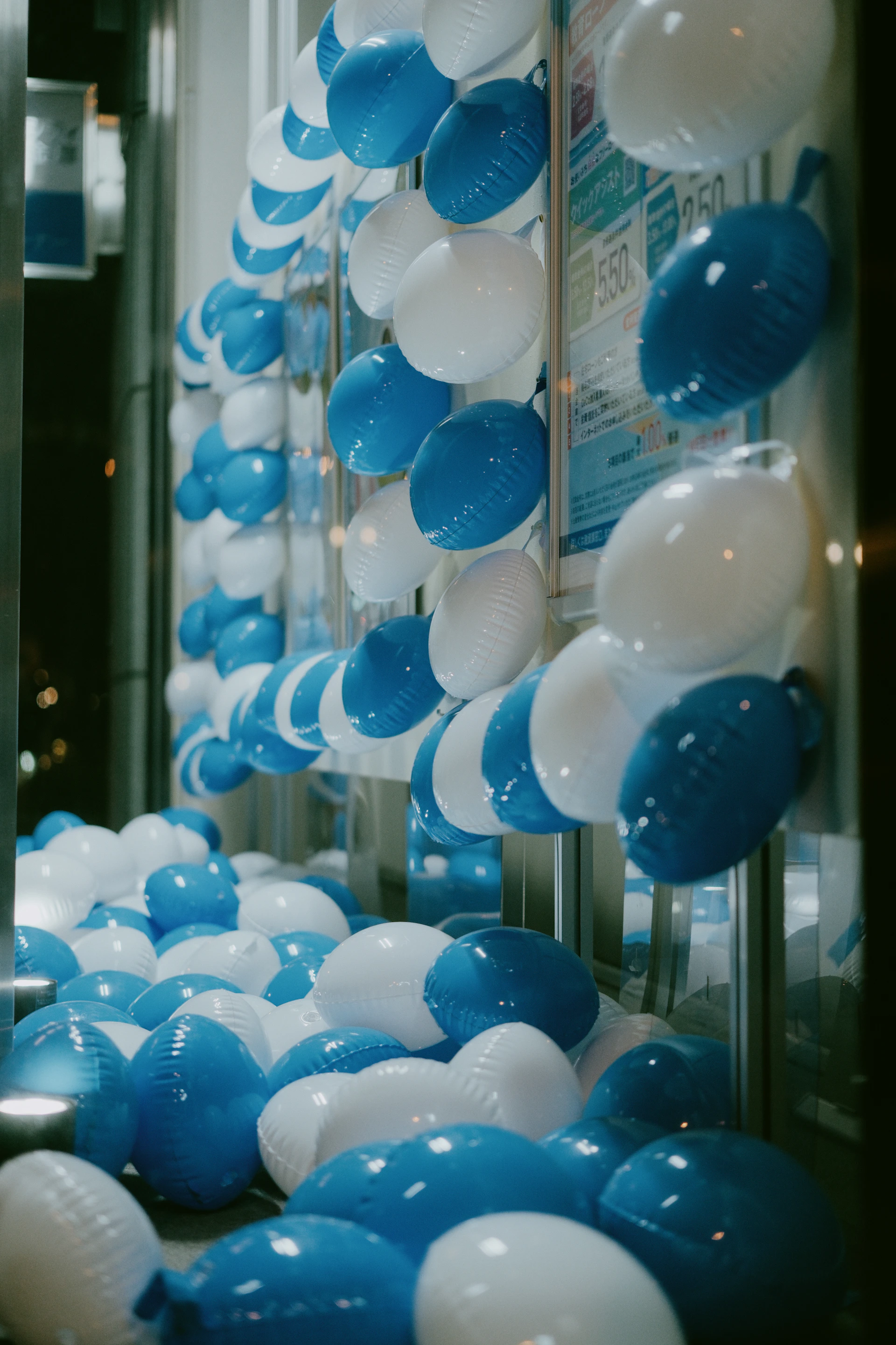 Blue and white balloons fill a display window.
