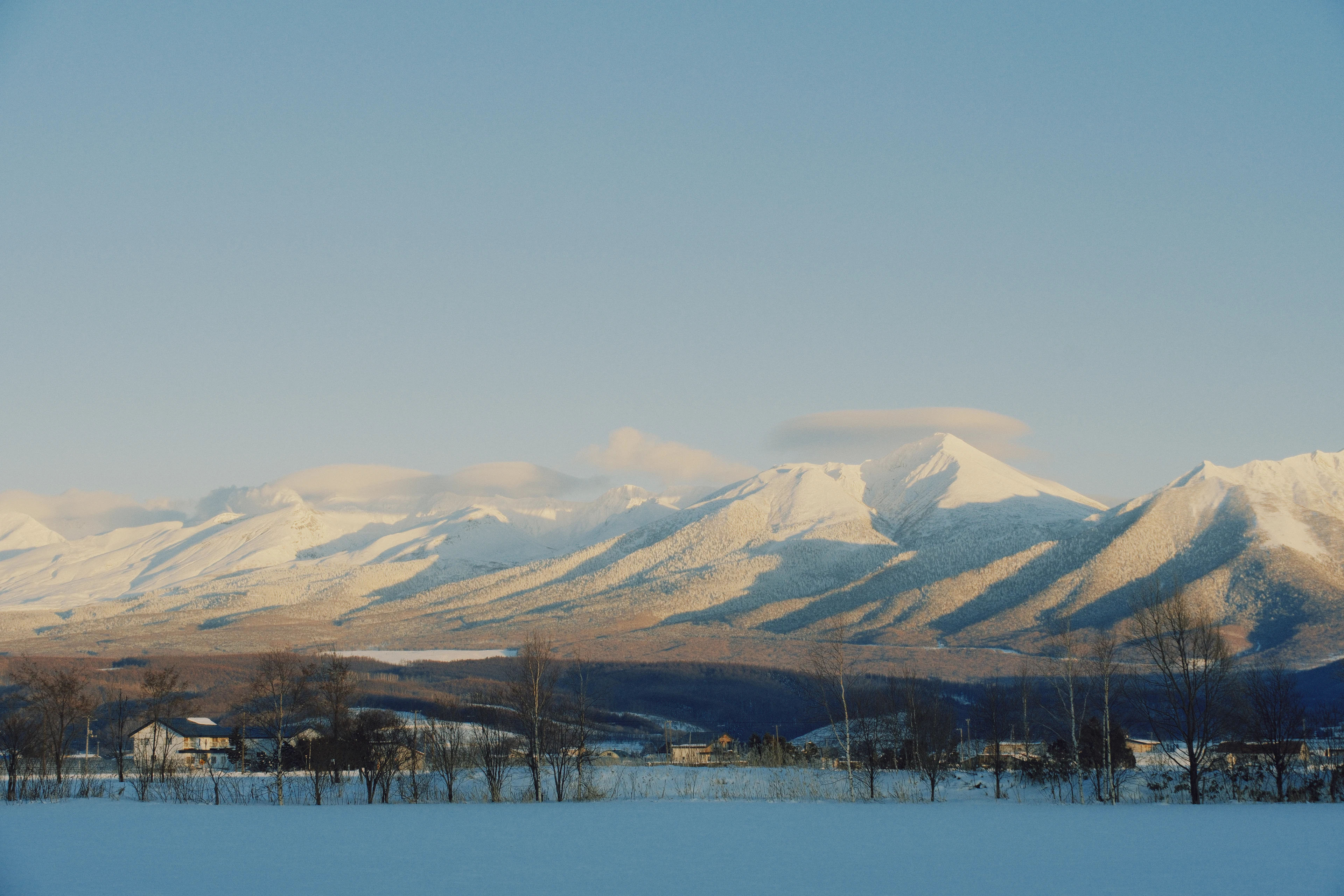 Snow-covered peaks above a farming village near Furano