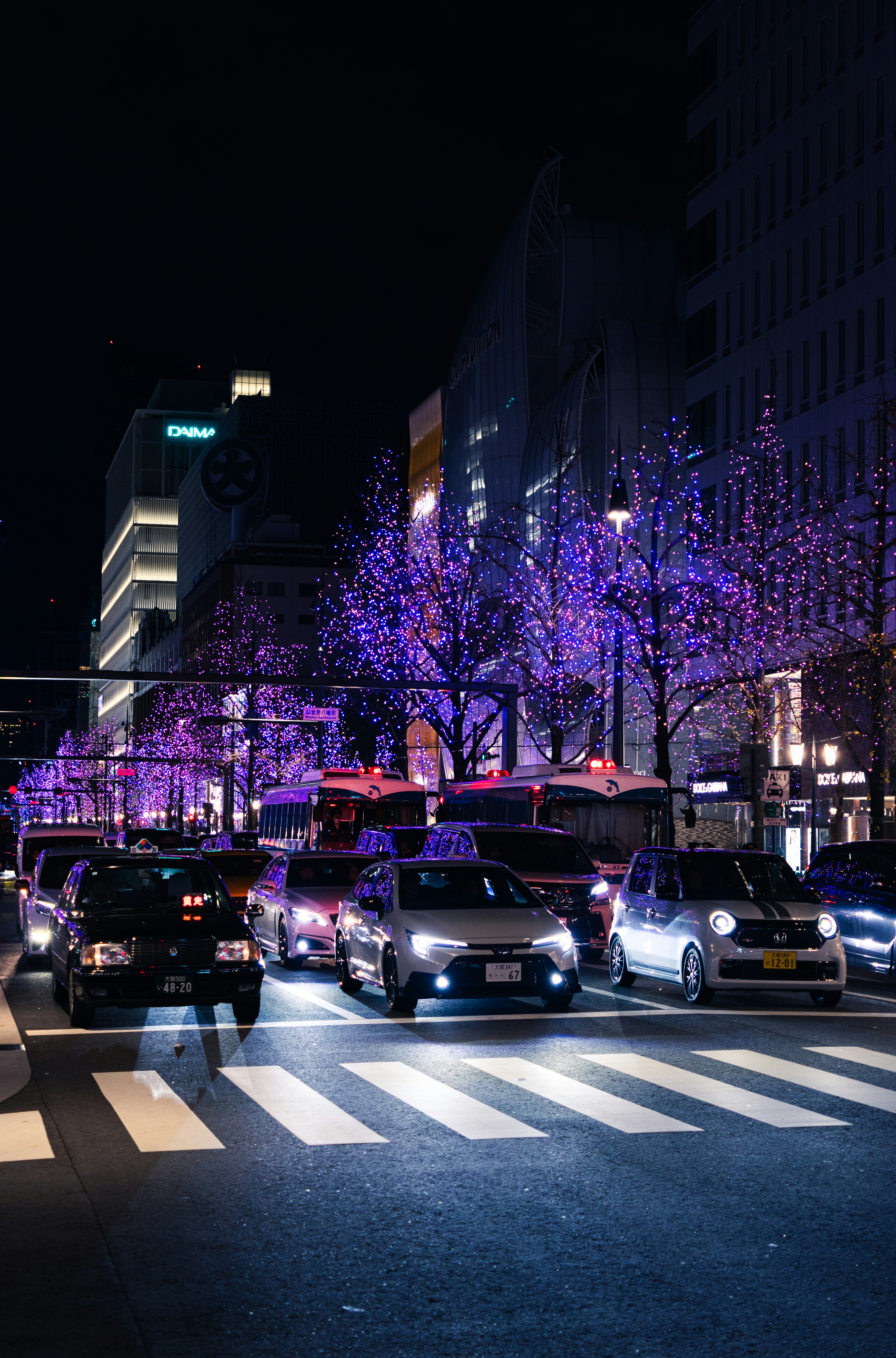 Cars at a busy street illuminated by purple lights