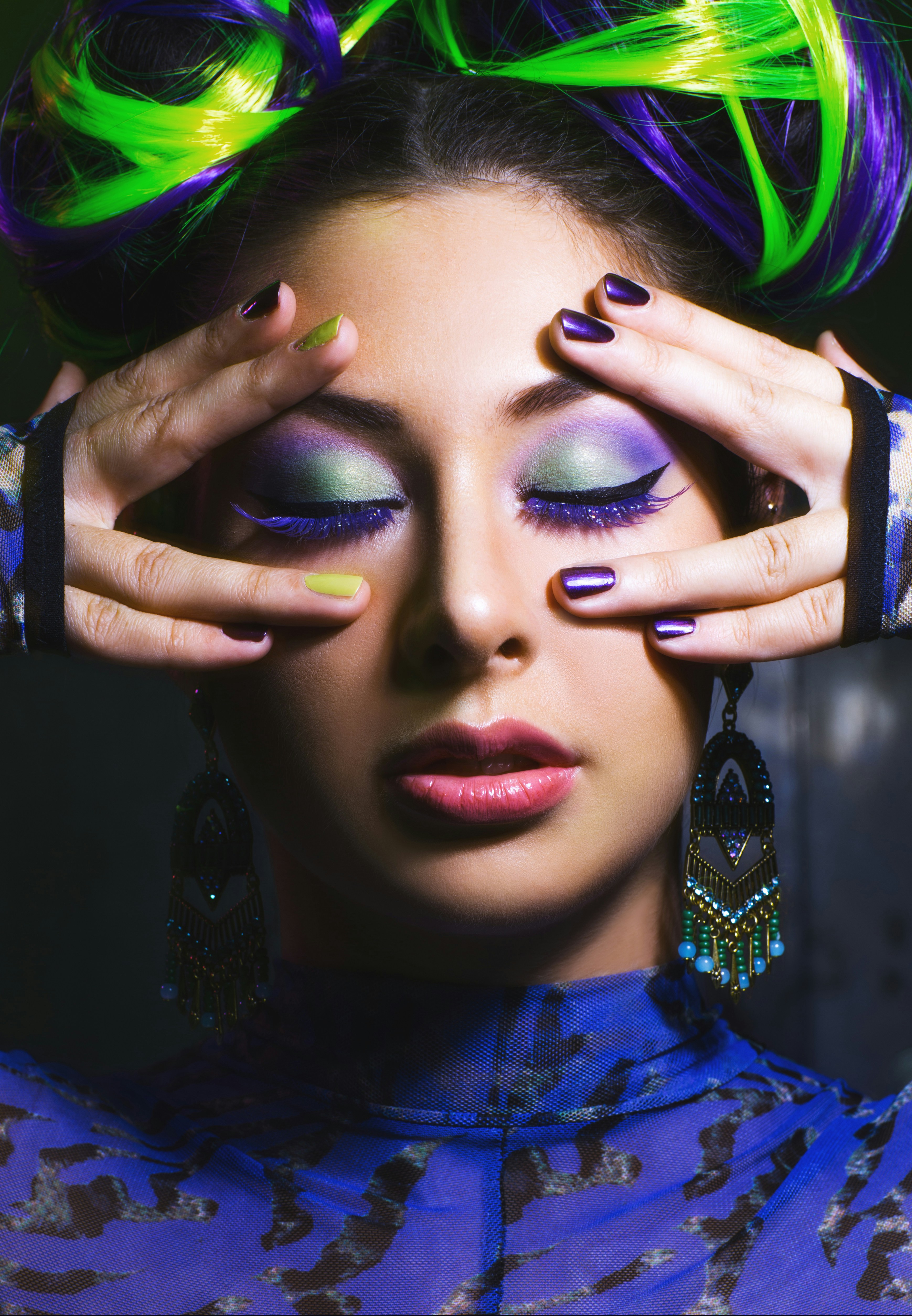 Woman with vibrant purple and green hair and makeup