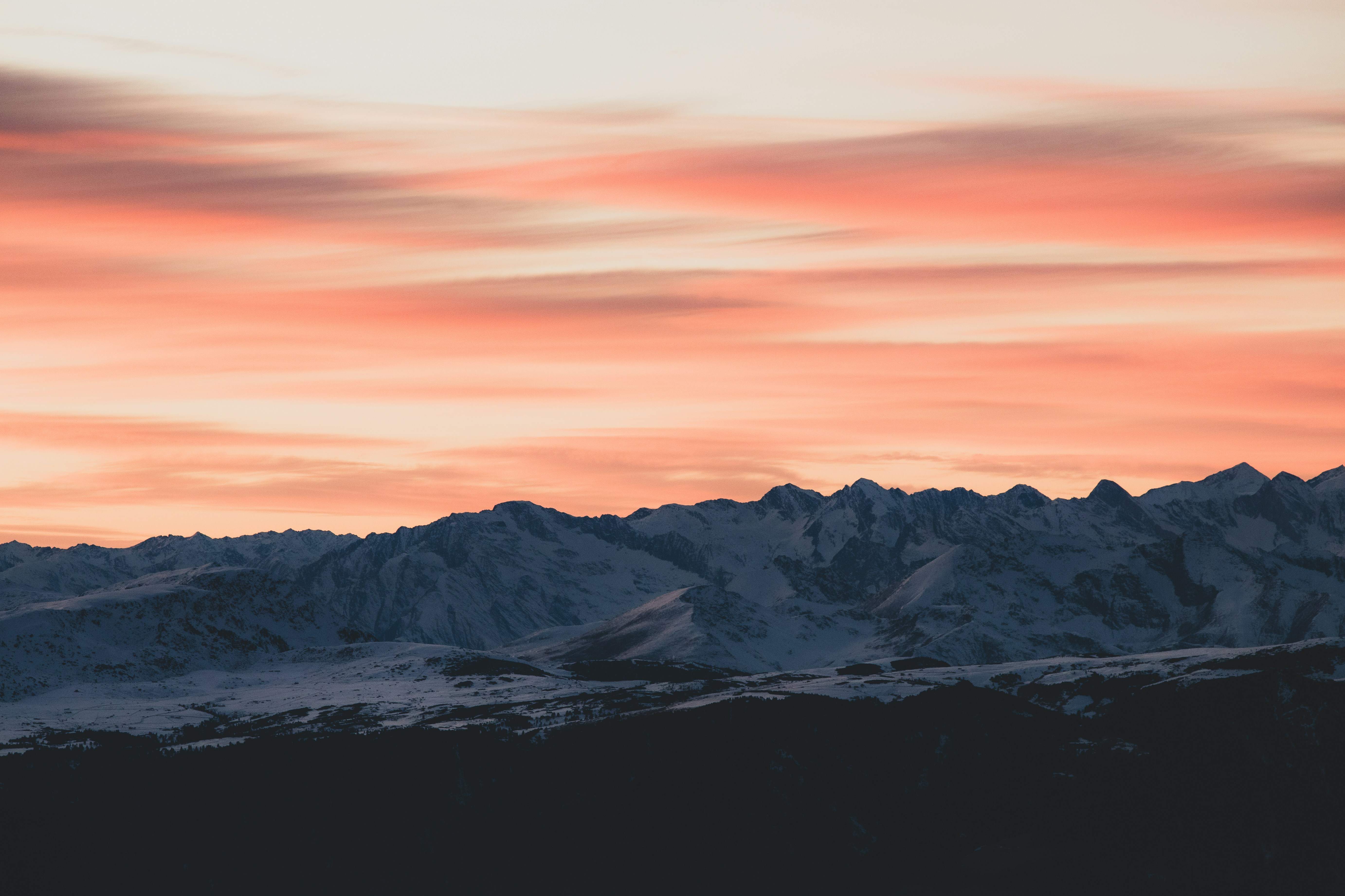 Snowy mountains under a vibrant pink and orange sky