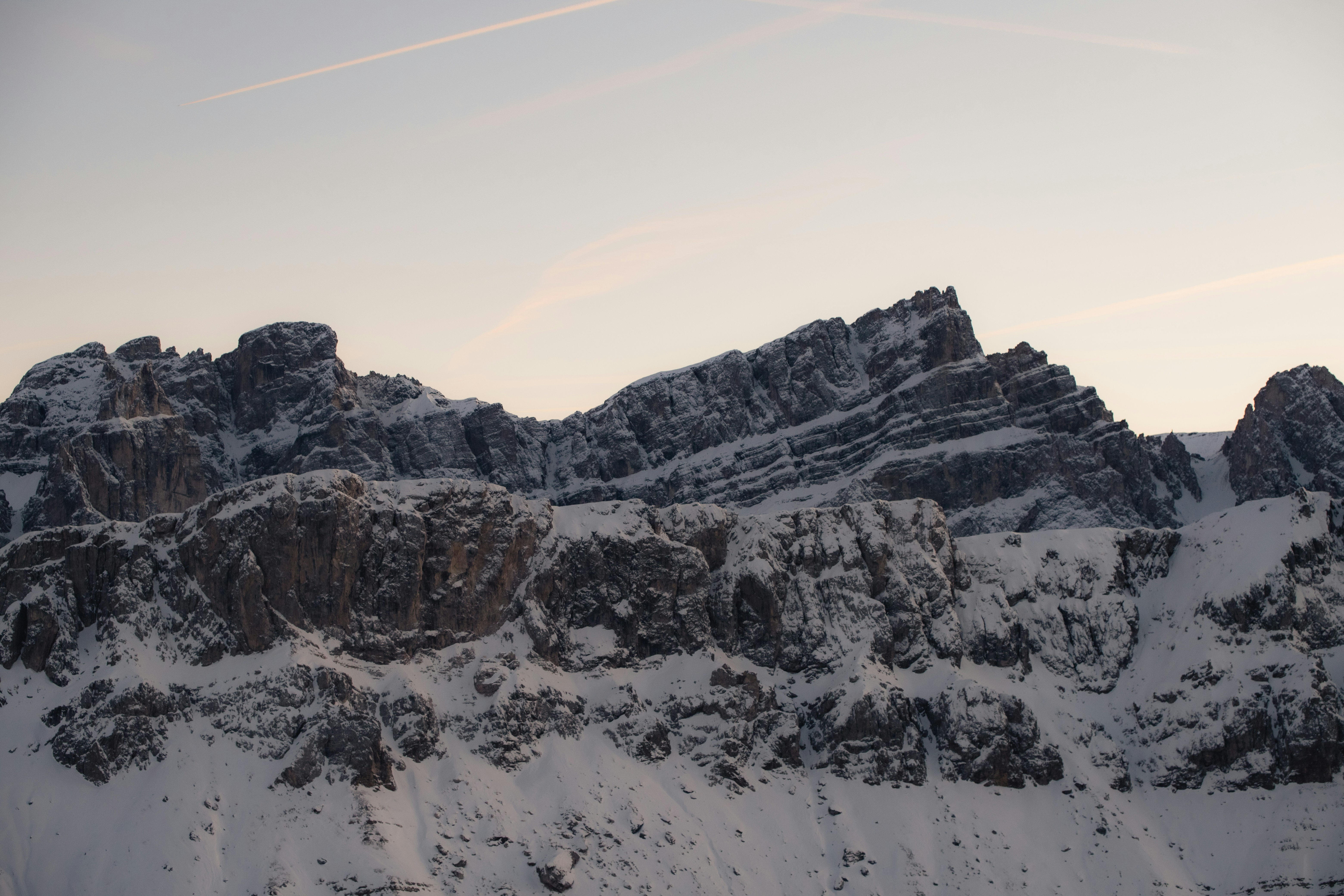 Snow-covered mountain range under a pale sky