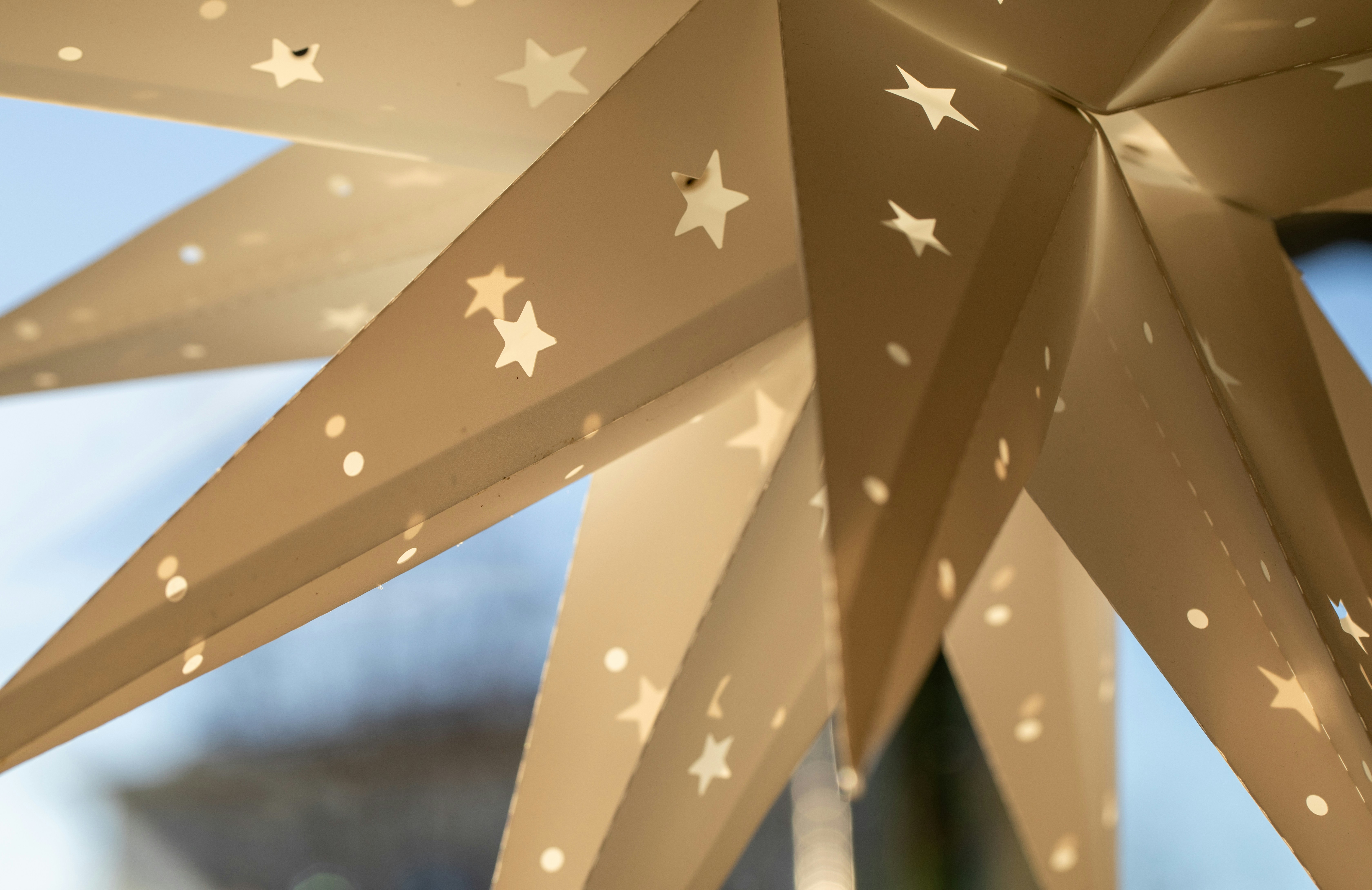 Close-up of a lit paper star lantern with cutouts.