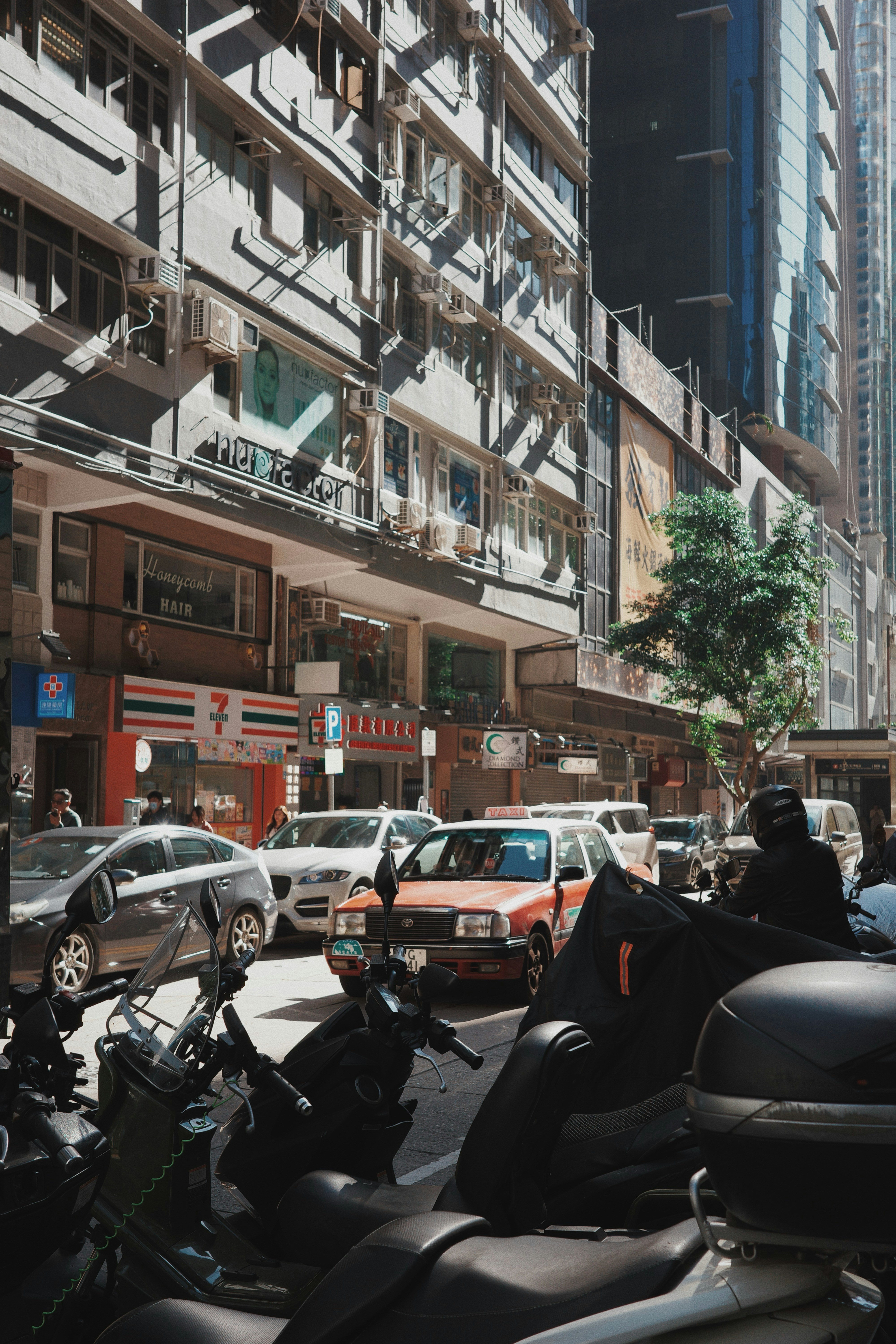 Busy street with cars, motorcycles, and buildings