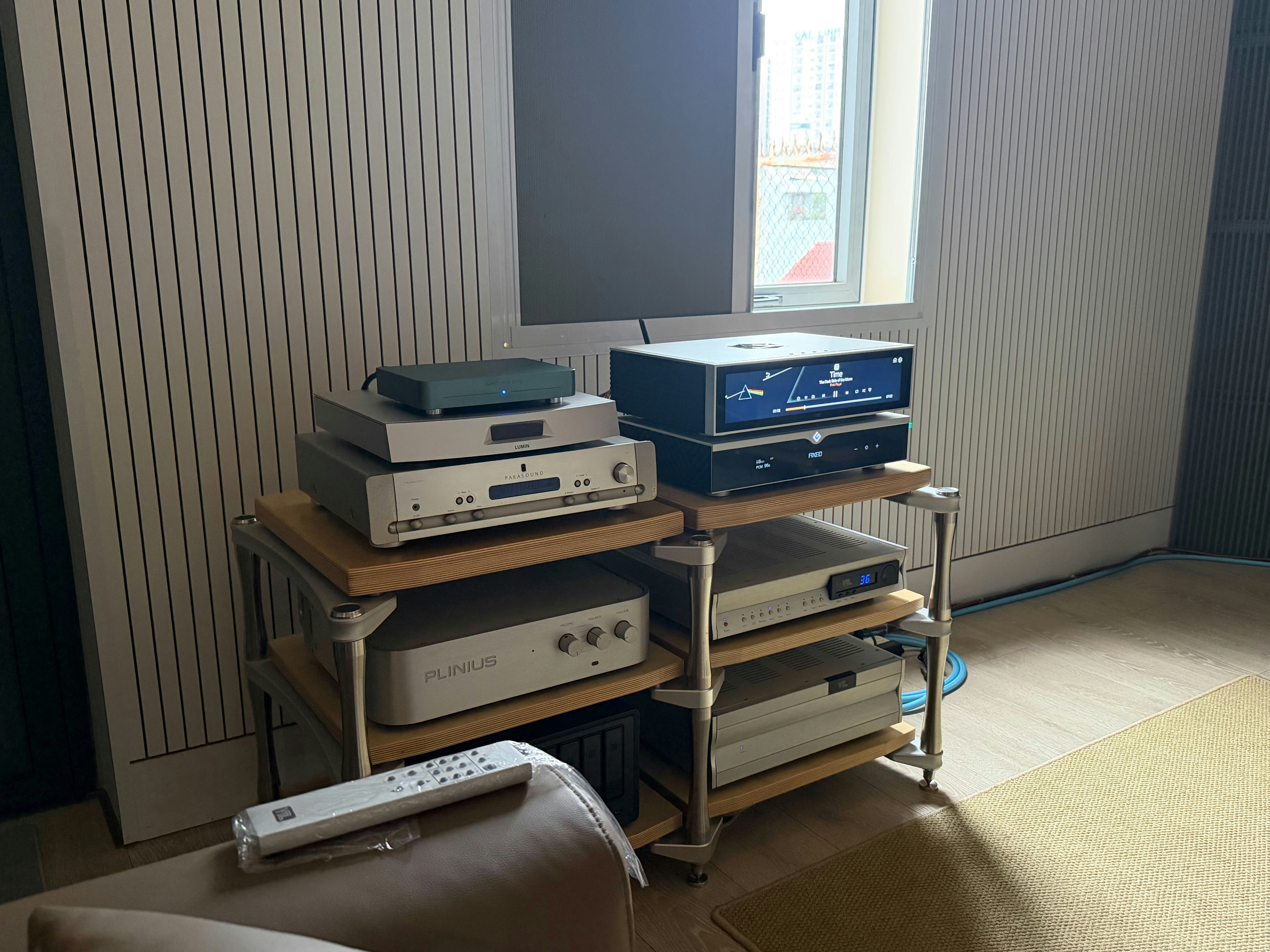 Pila de equipos de audio en estanterías con mando a distancia.