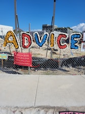 Colorful letters spell out advice on a fence.