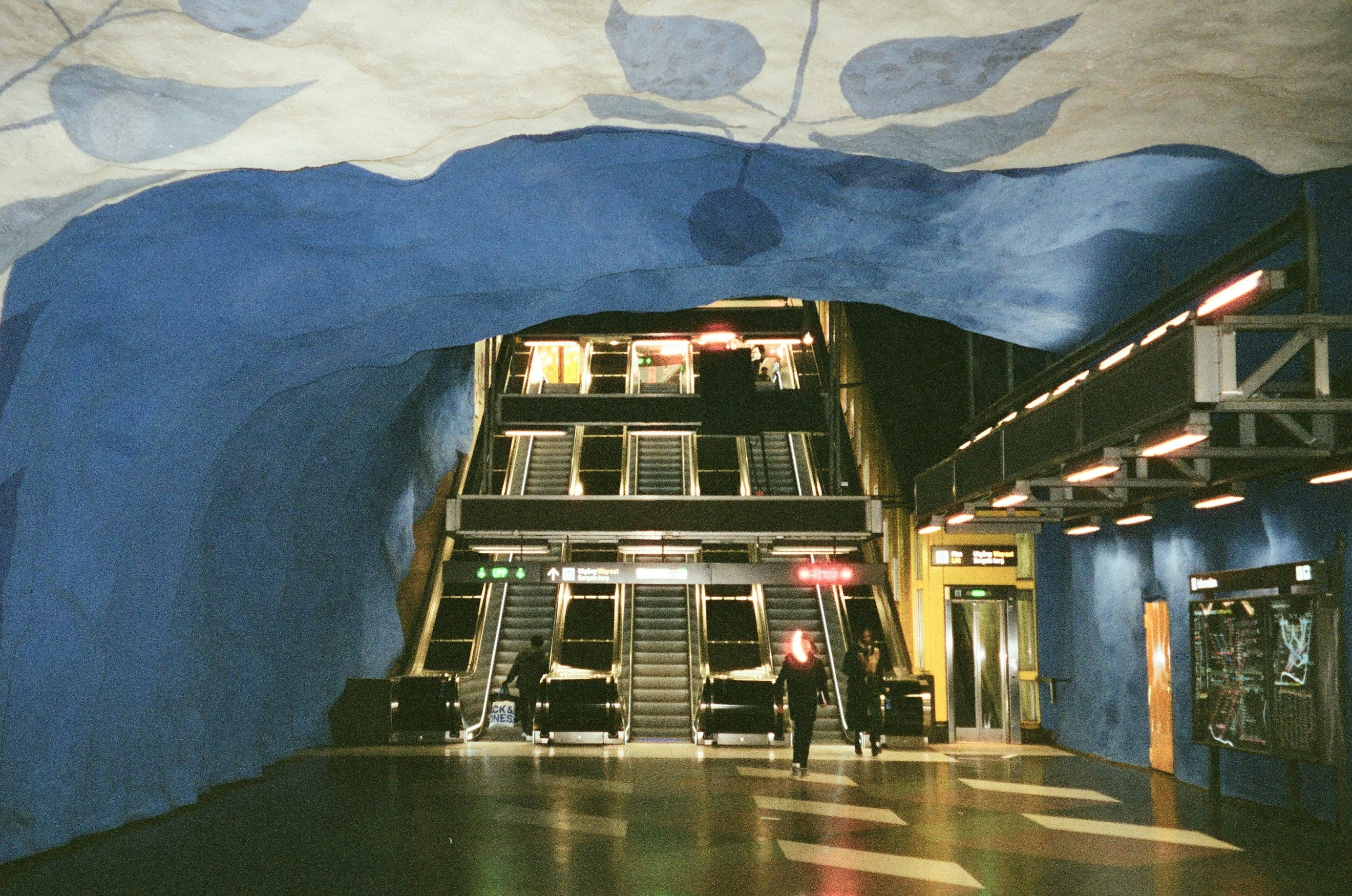 Modern subway station with blue walls and escalators