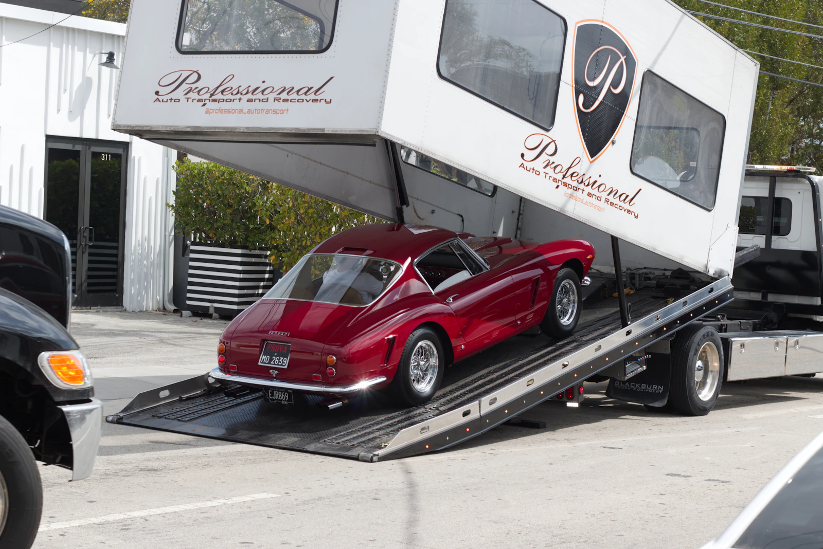 Classic red Ferrari being loaded into an enclosed car transporter