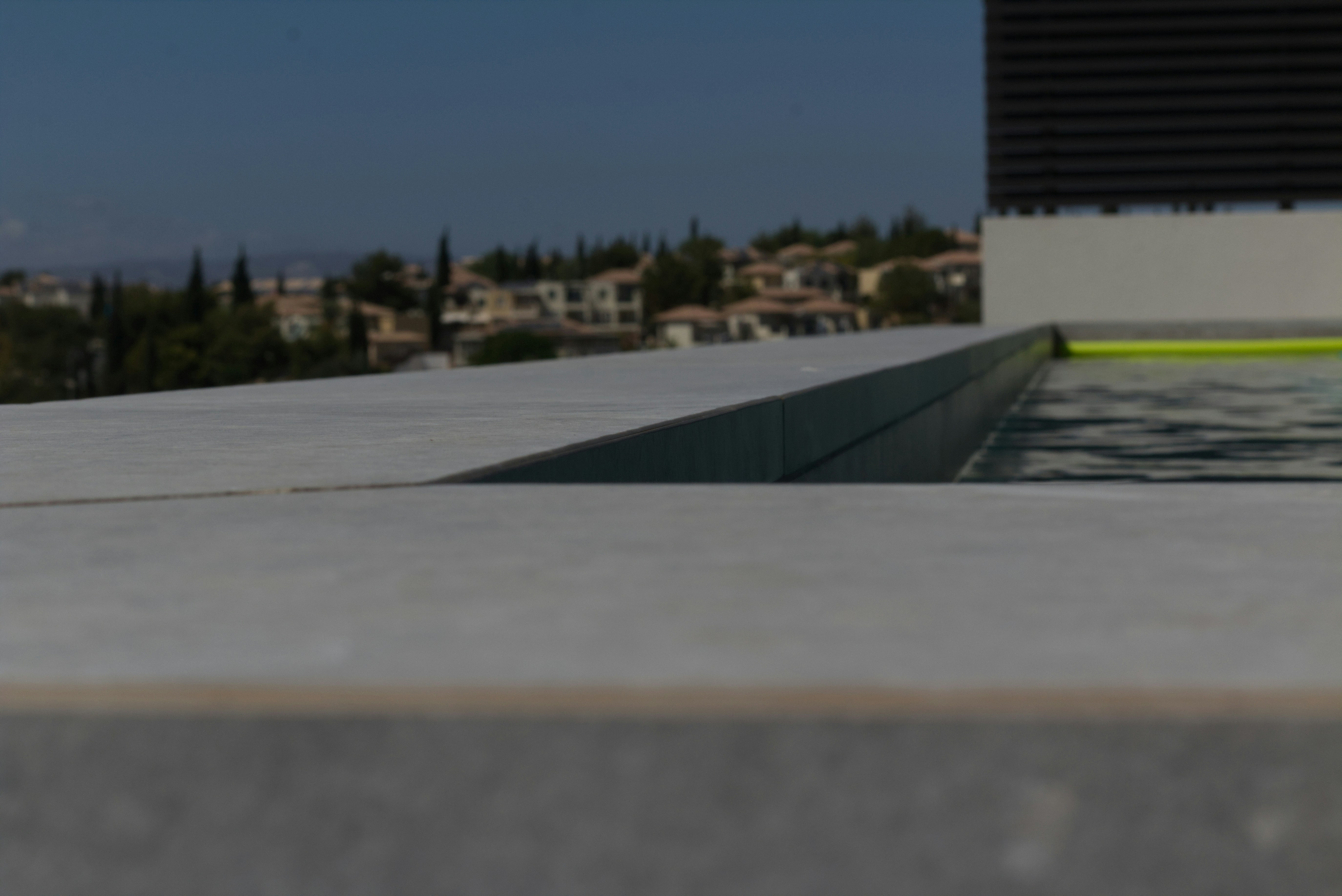 Modern infinity pool overlooking a scenic hillside town.