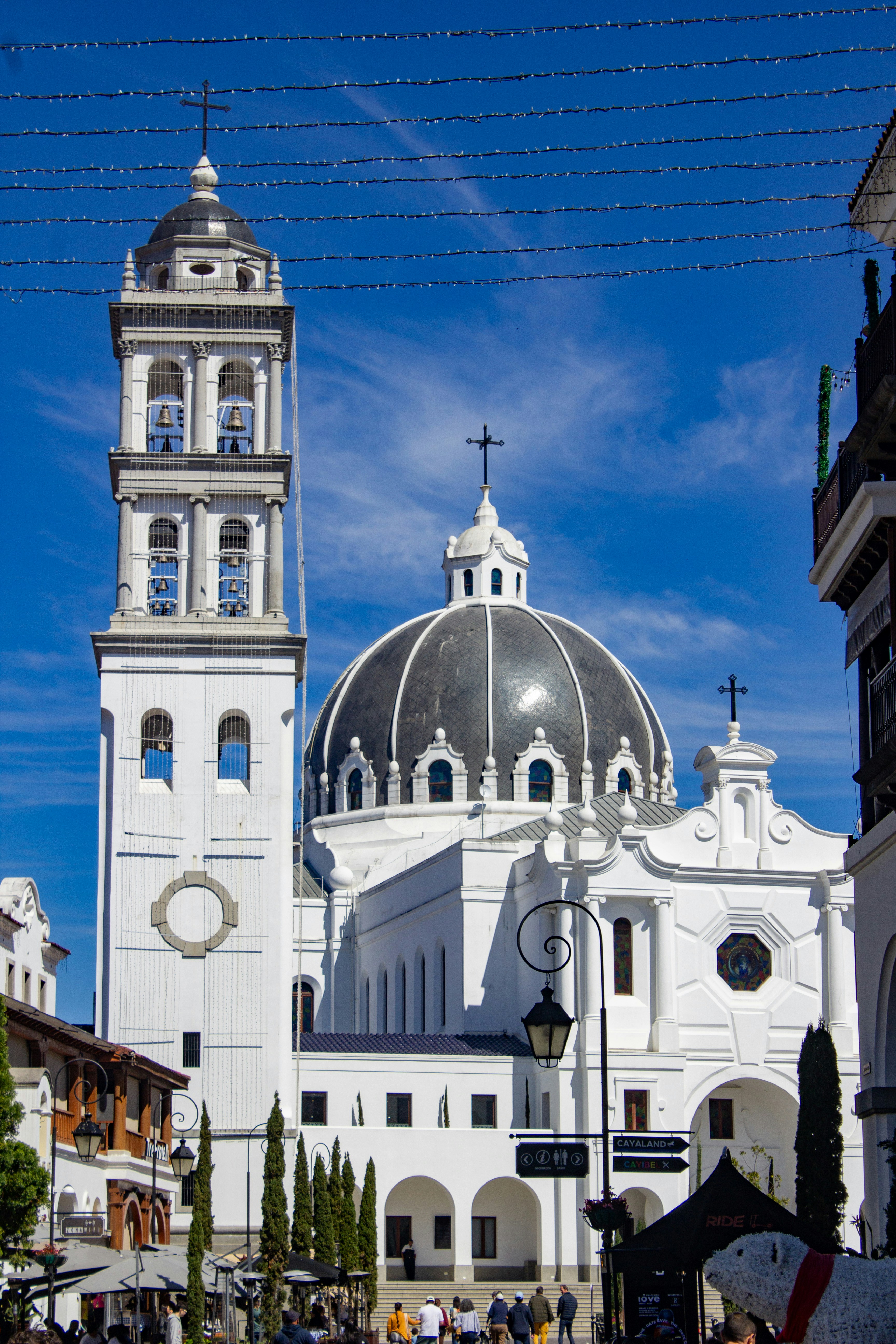 White church with black dome under blue sky.