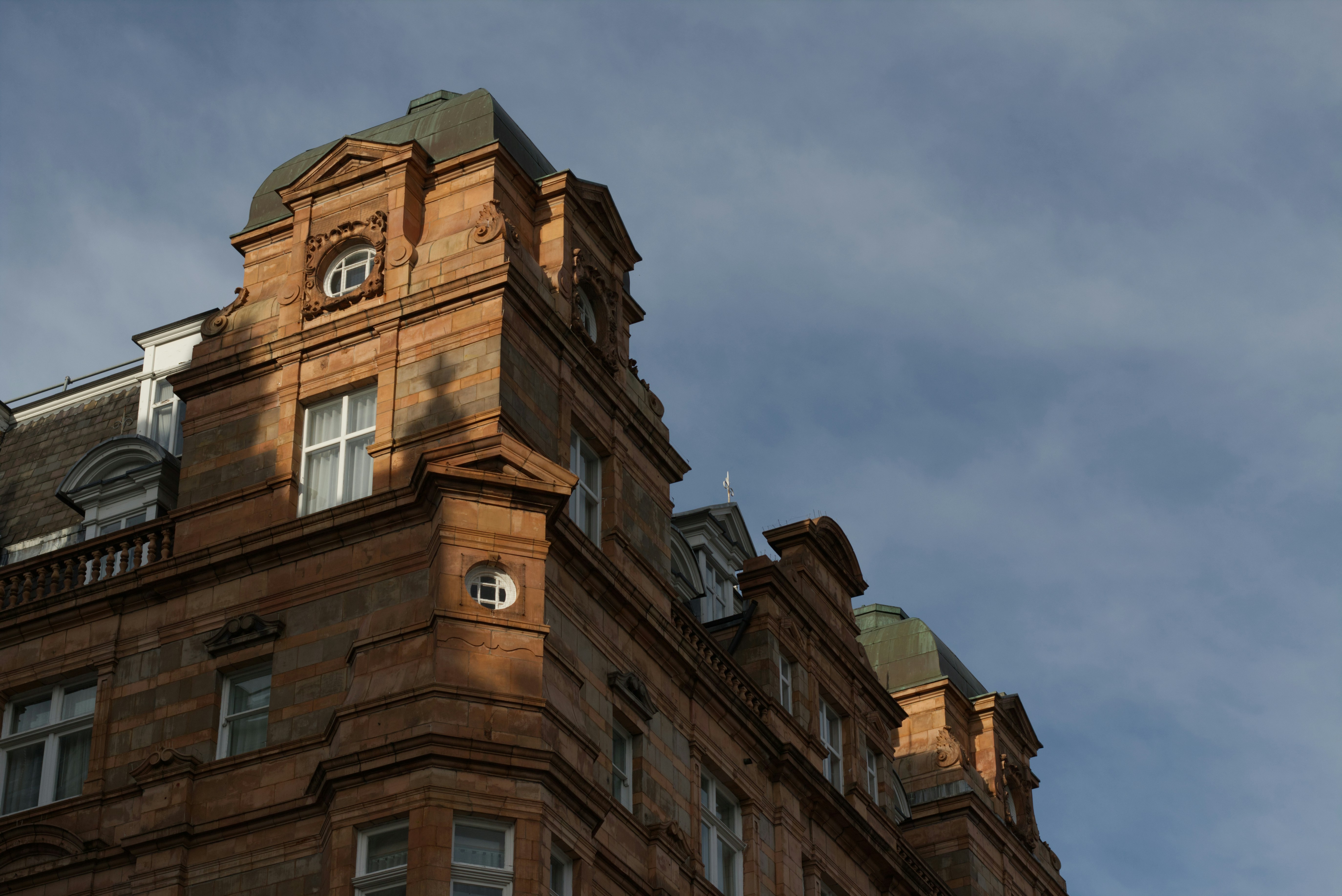 Ornate stone building with mansard roofs against sky