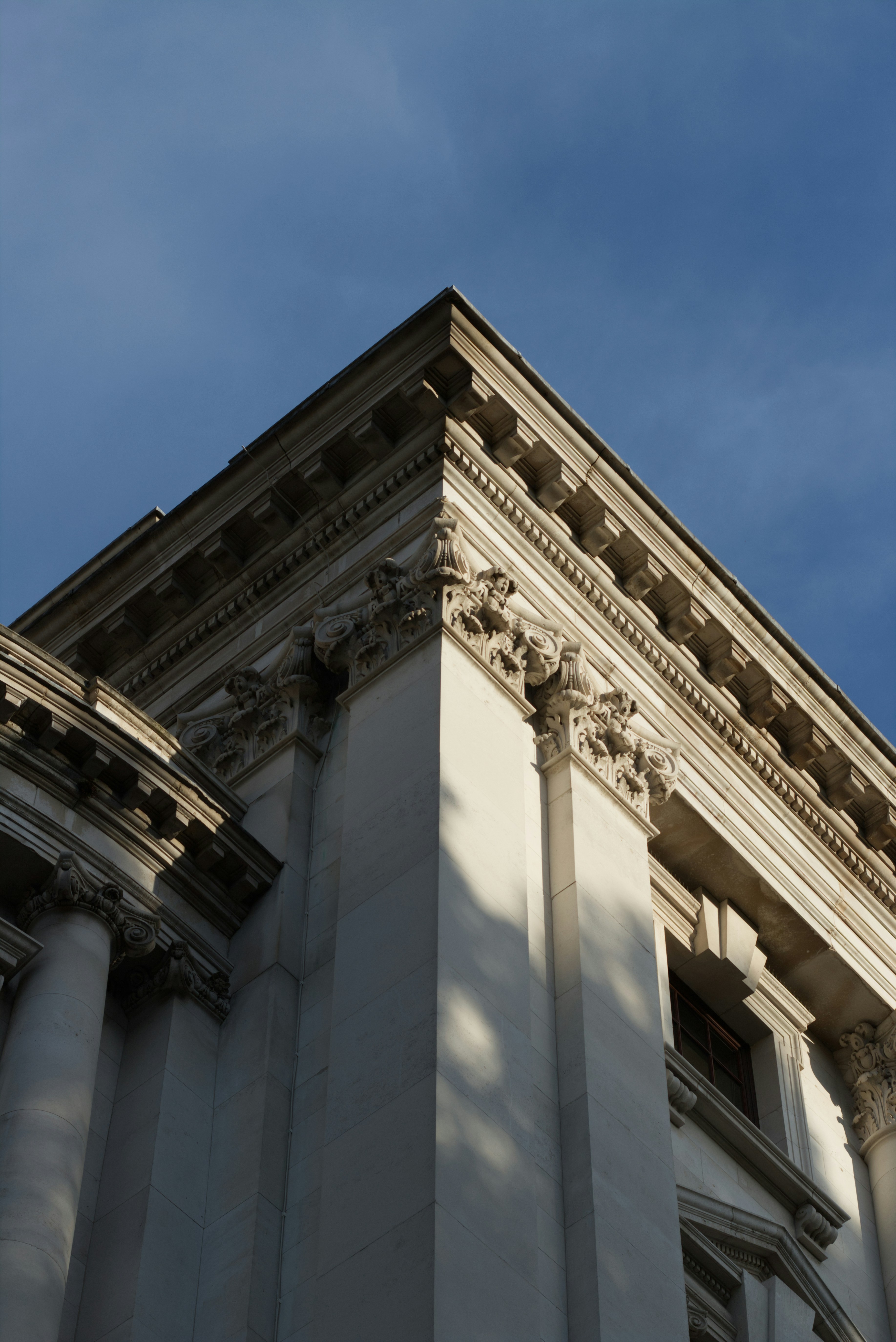 Corner of a grand building against blue sky