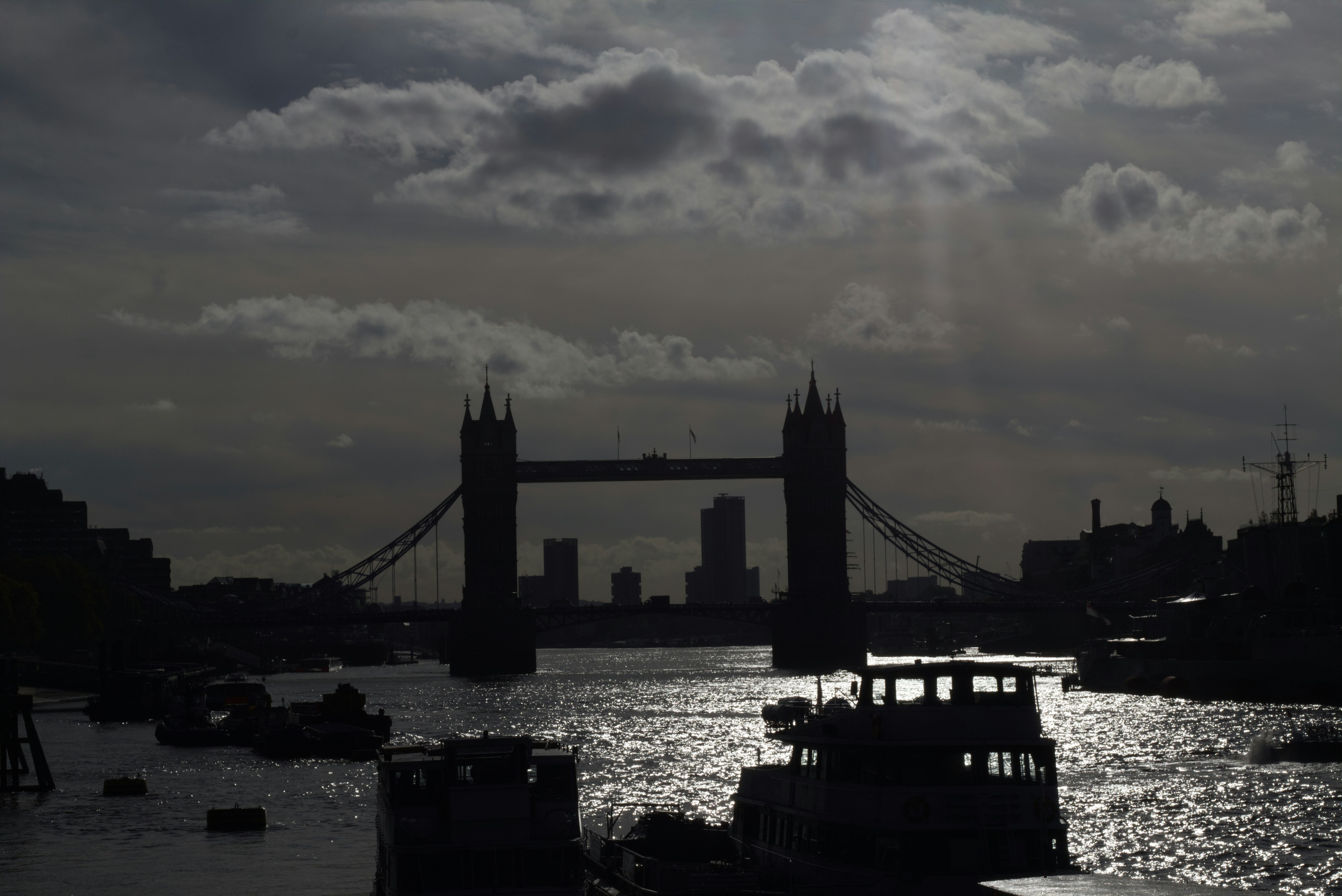 Tower bridge silhouetted against a cloudy sky