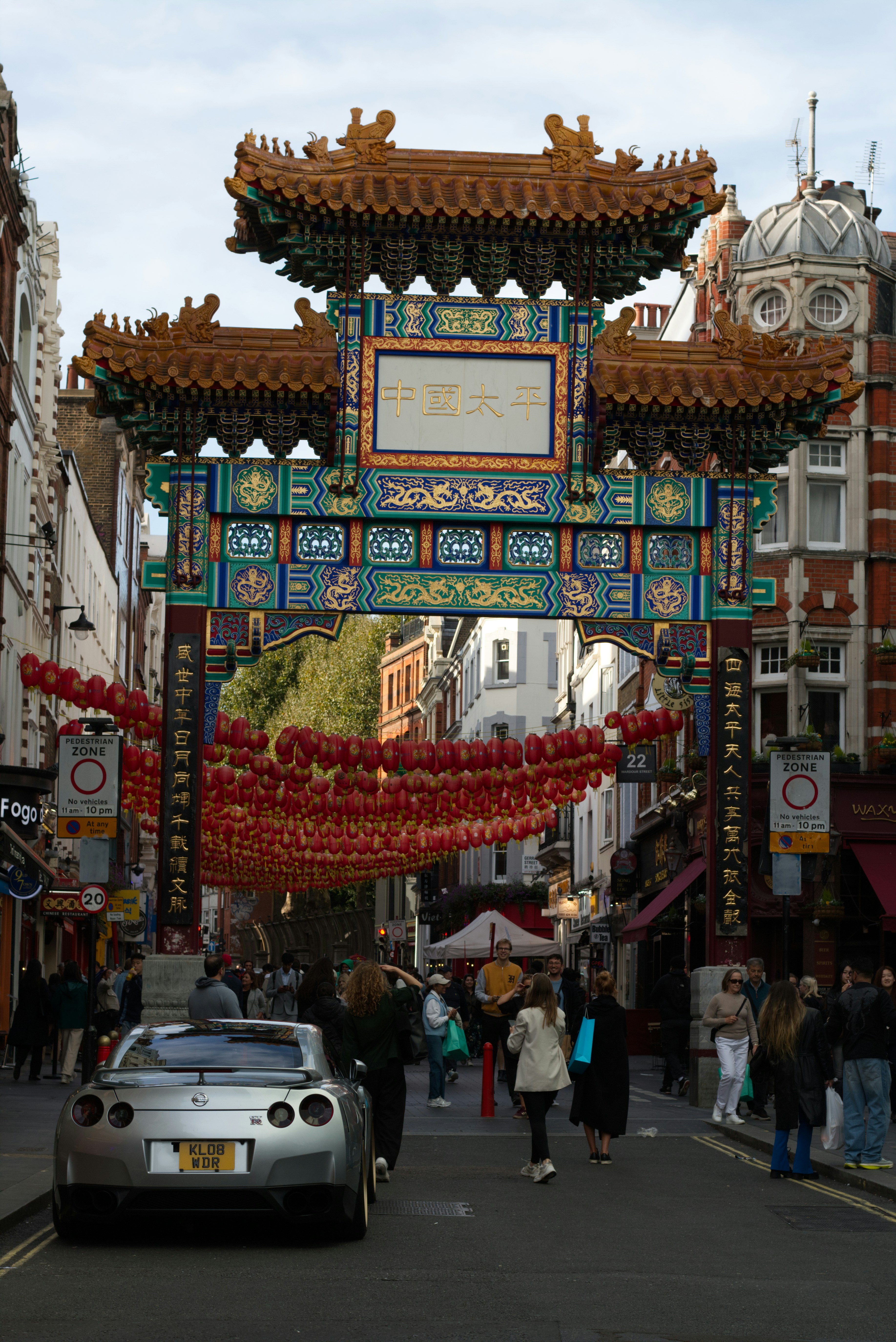Chinese archway with red lanterns and people