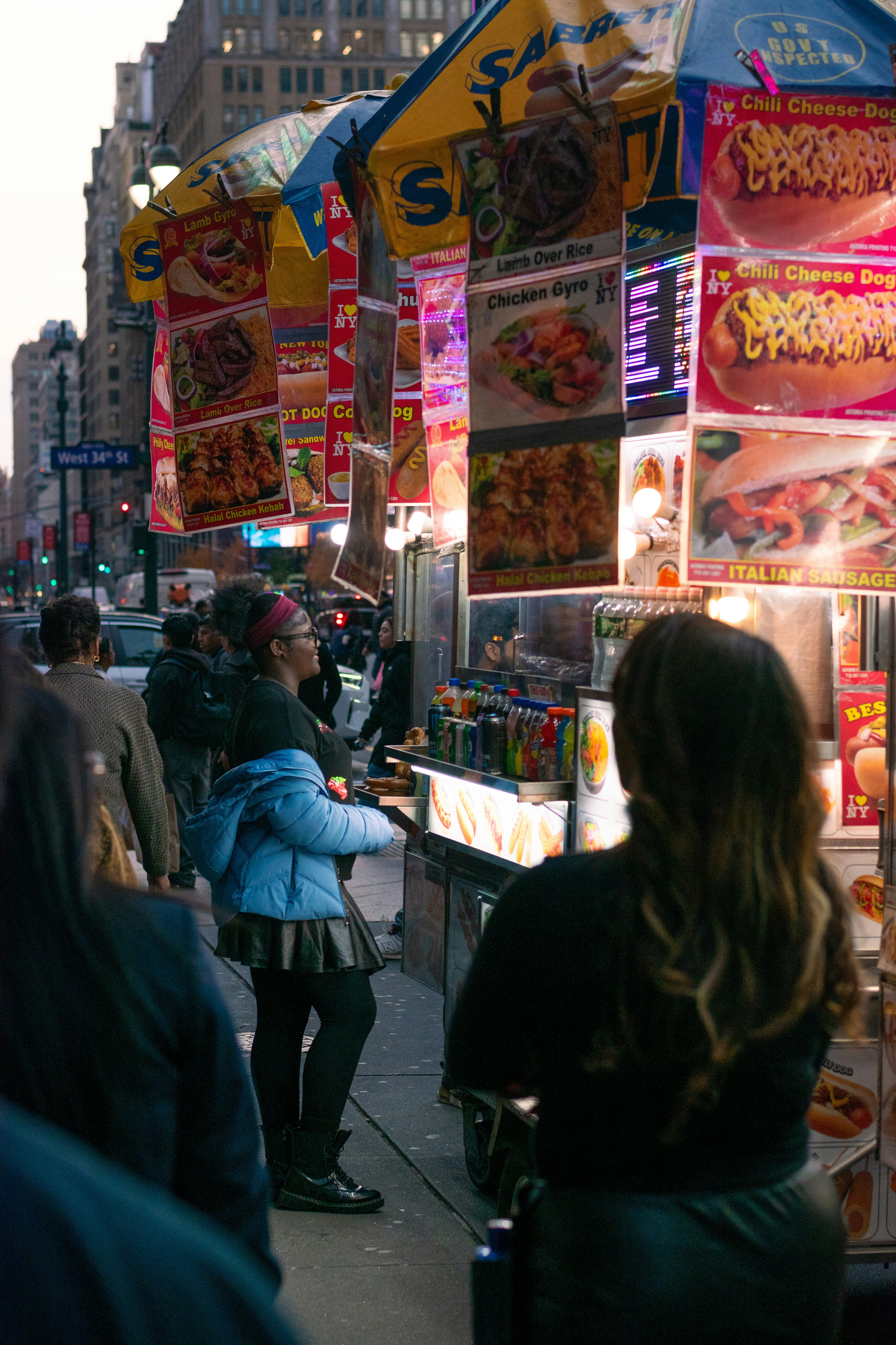 People ordering food from a new york city street vendor