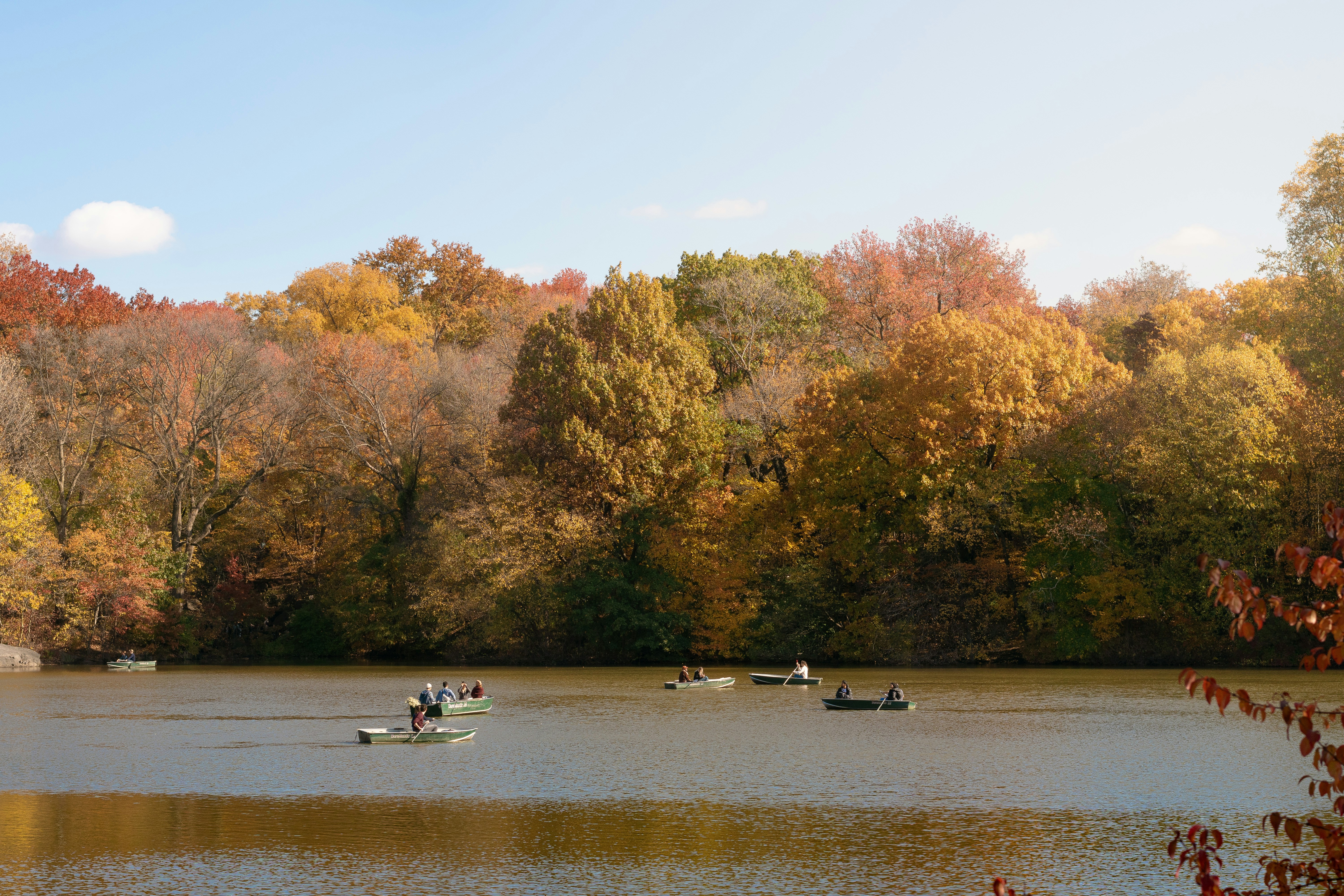 Boats on a lake with autumn trees in the background