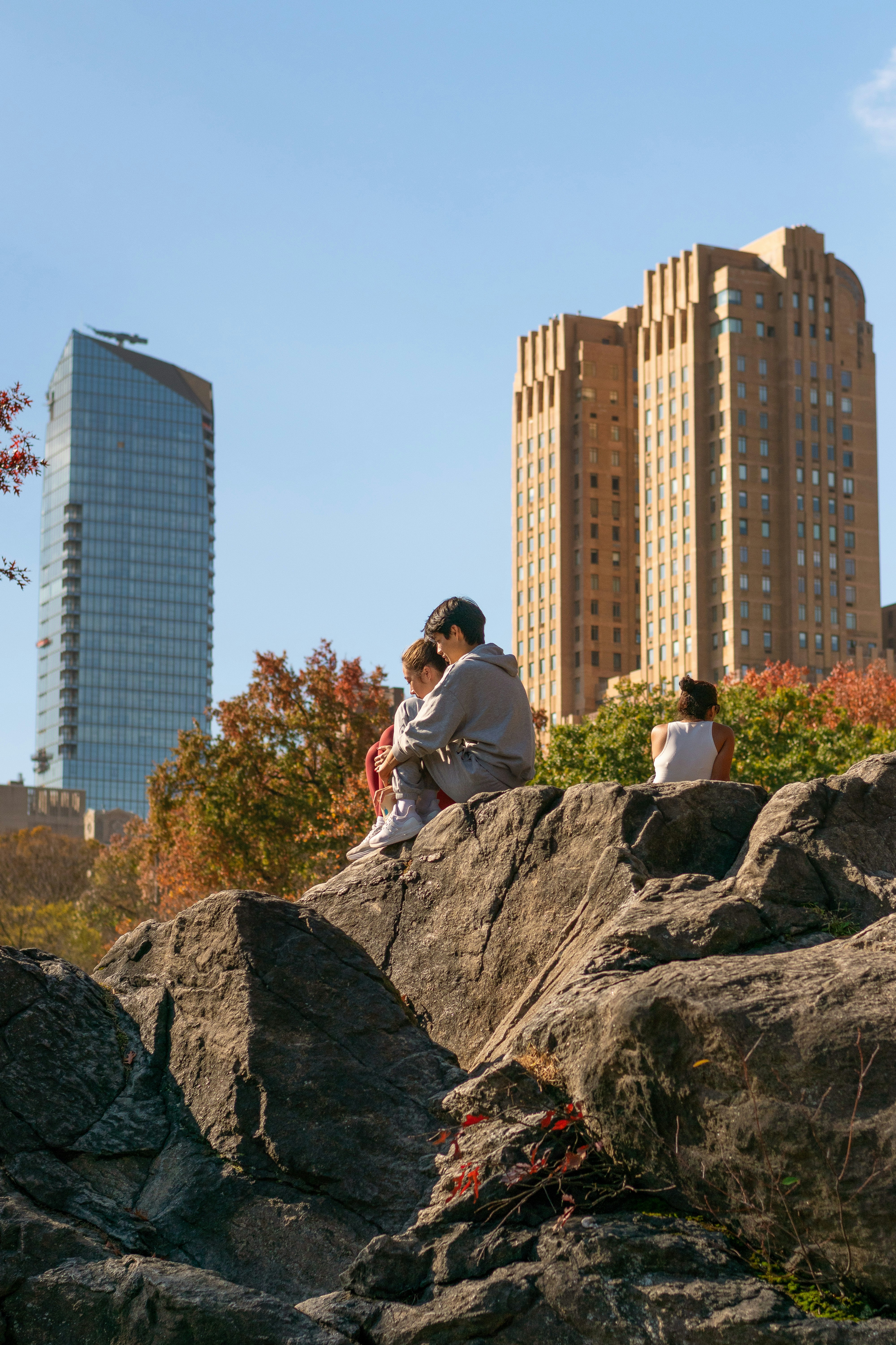 People sitting on rocks with city buildings behind them