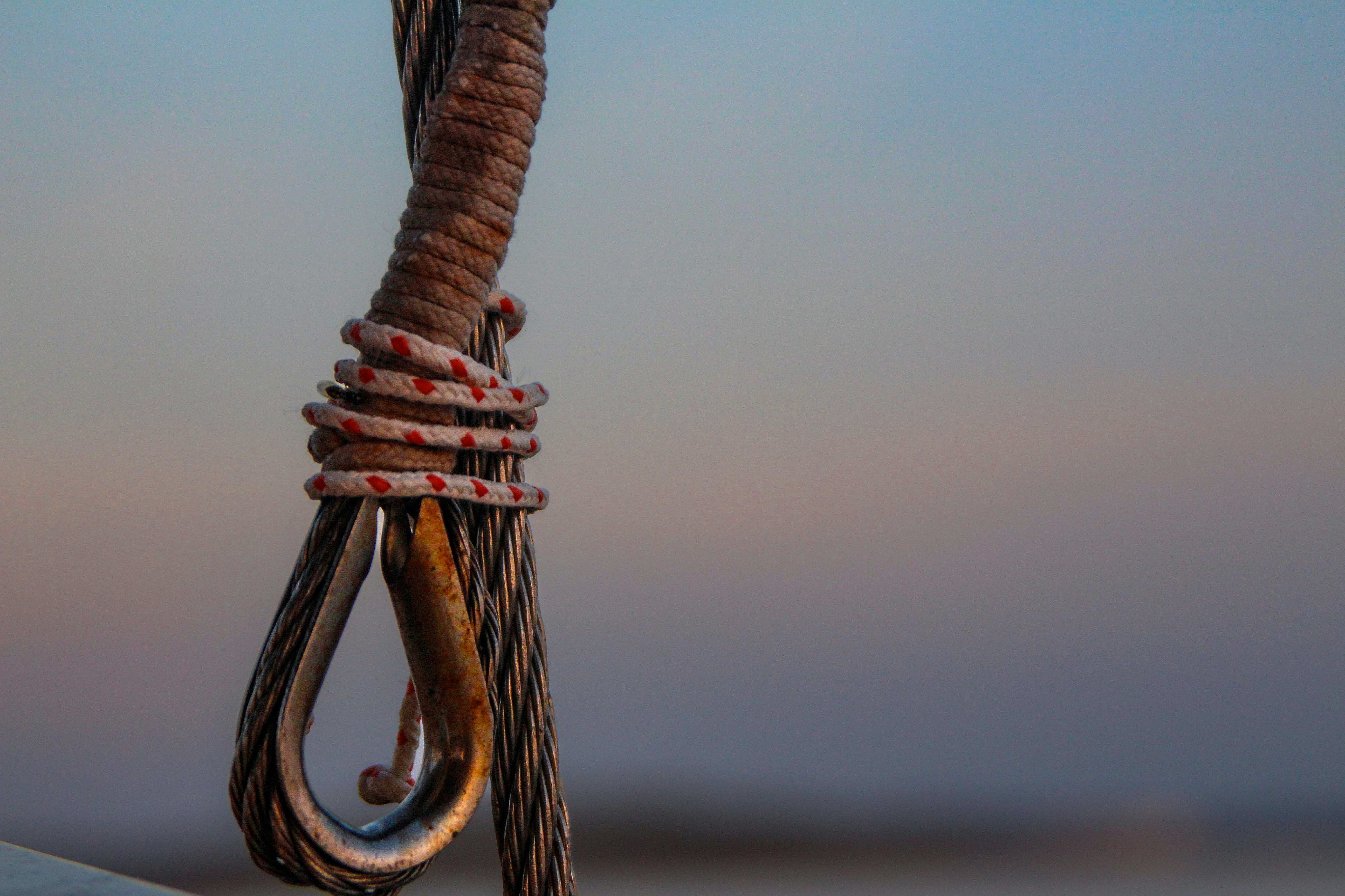 Close-up of a metal cable with rope tied rope
