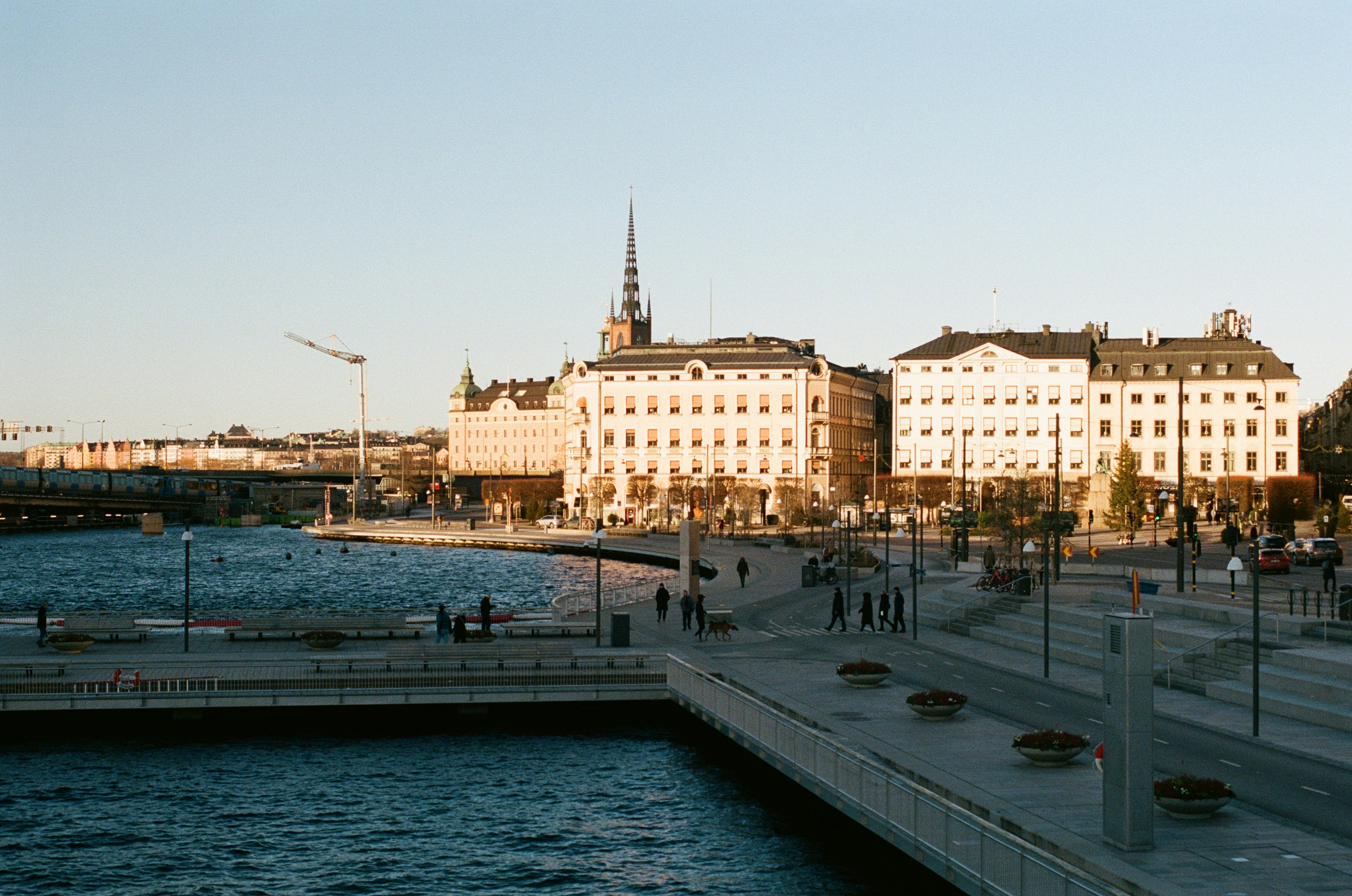 City skyline with waterfront promenade and buildings.