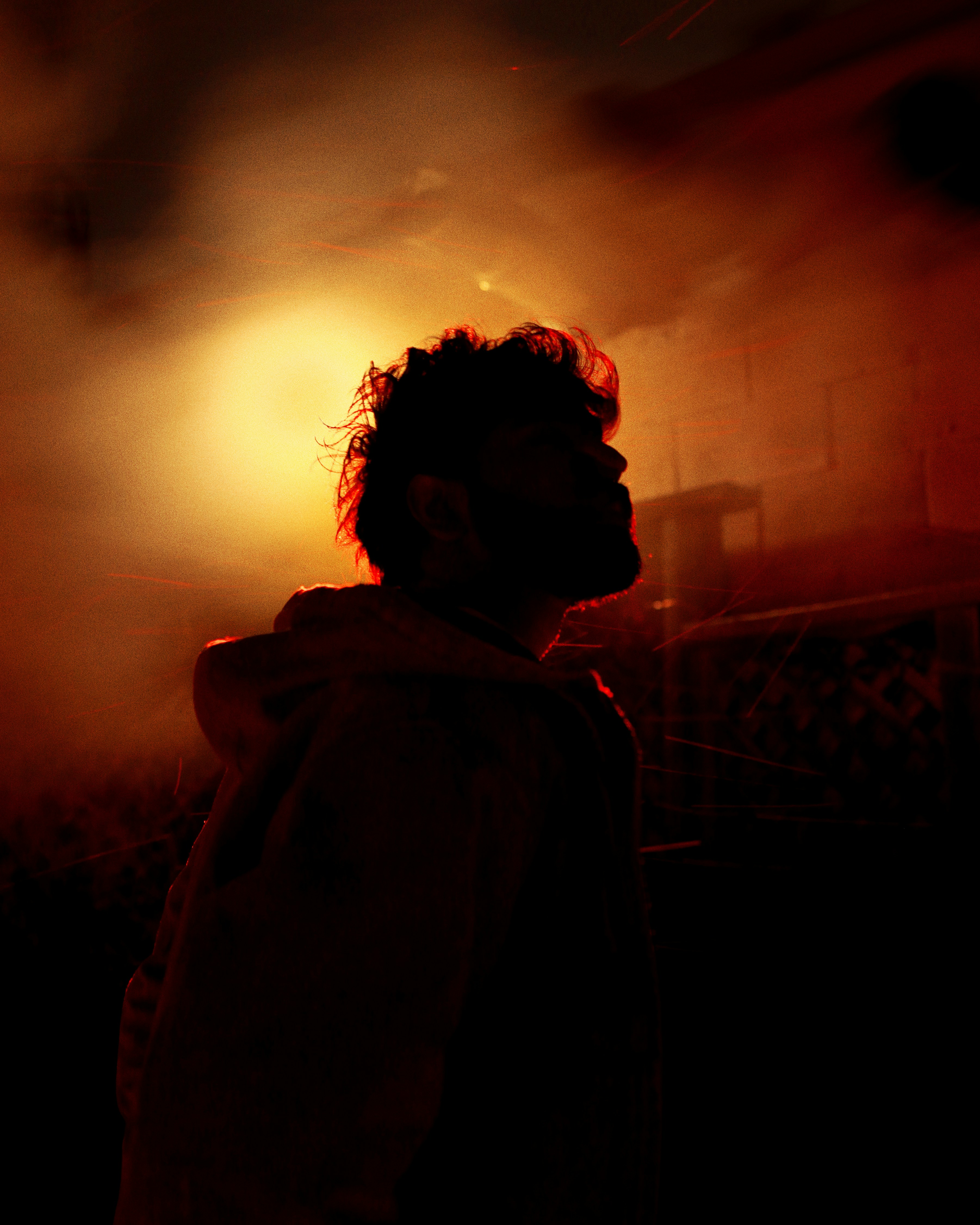 Man silhouetted against a bright orange light