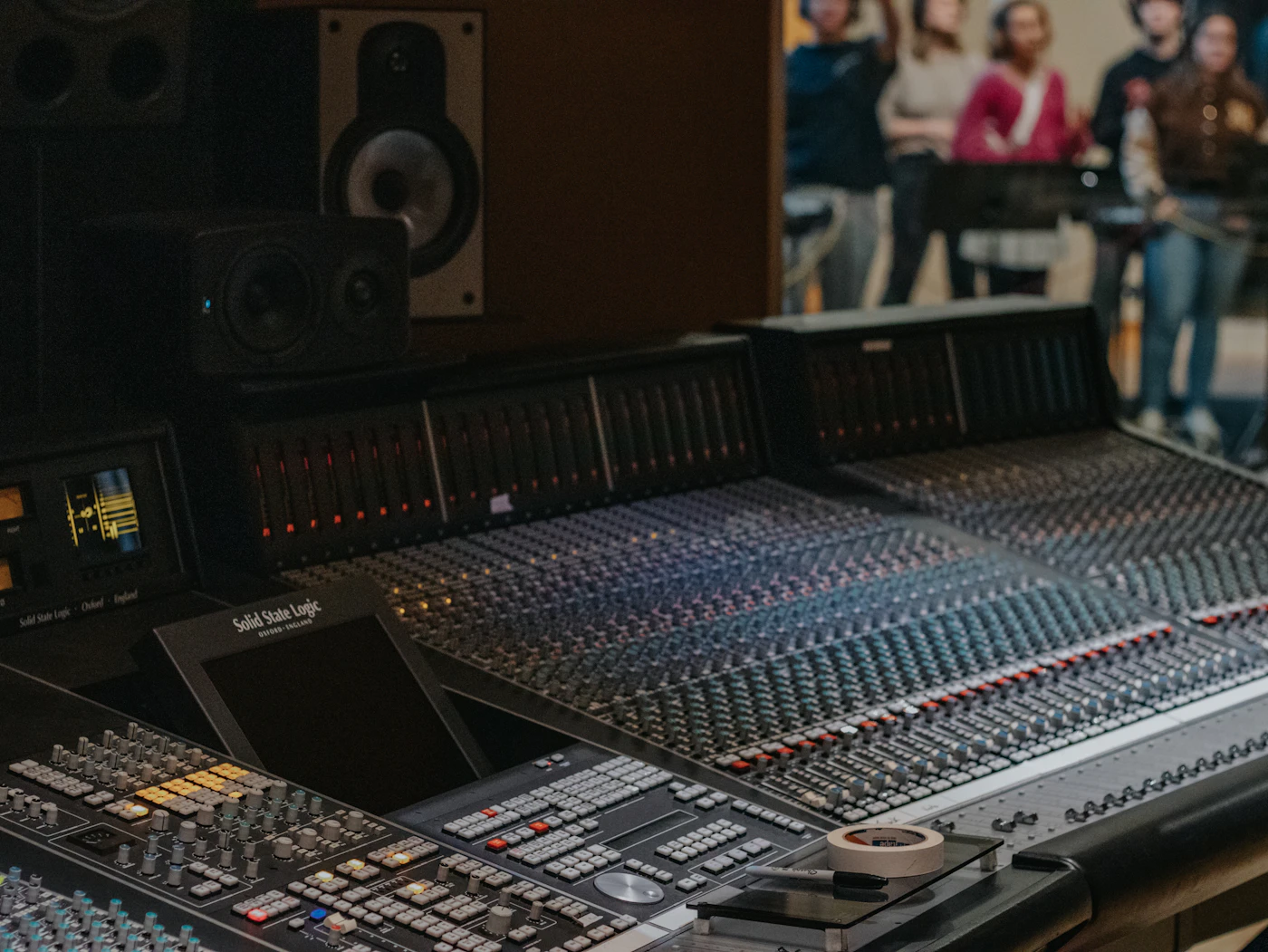 Recording studio console with producers working in the background