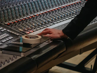 Hand operating a professional audio mixing console