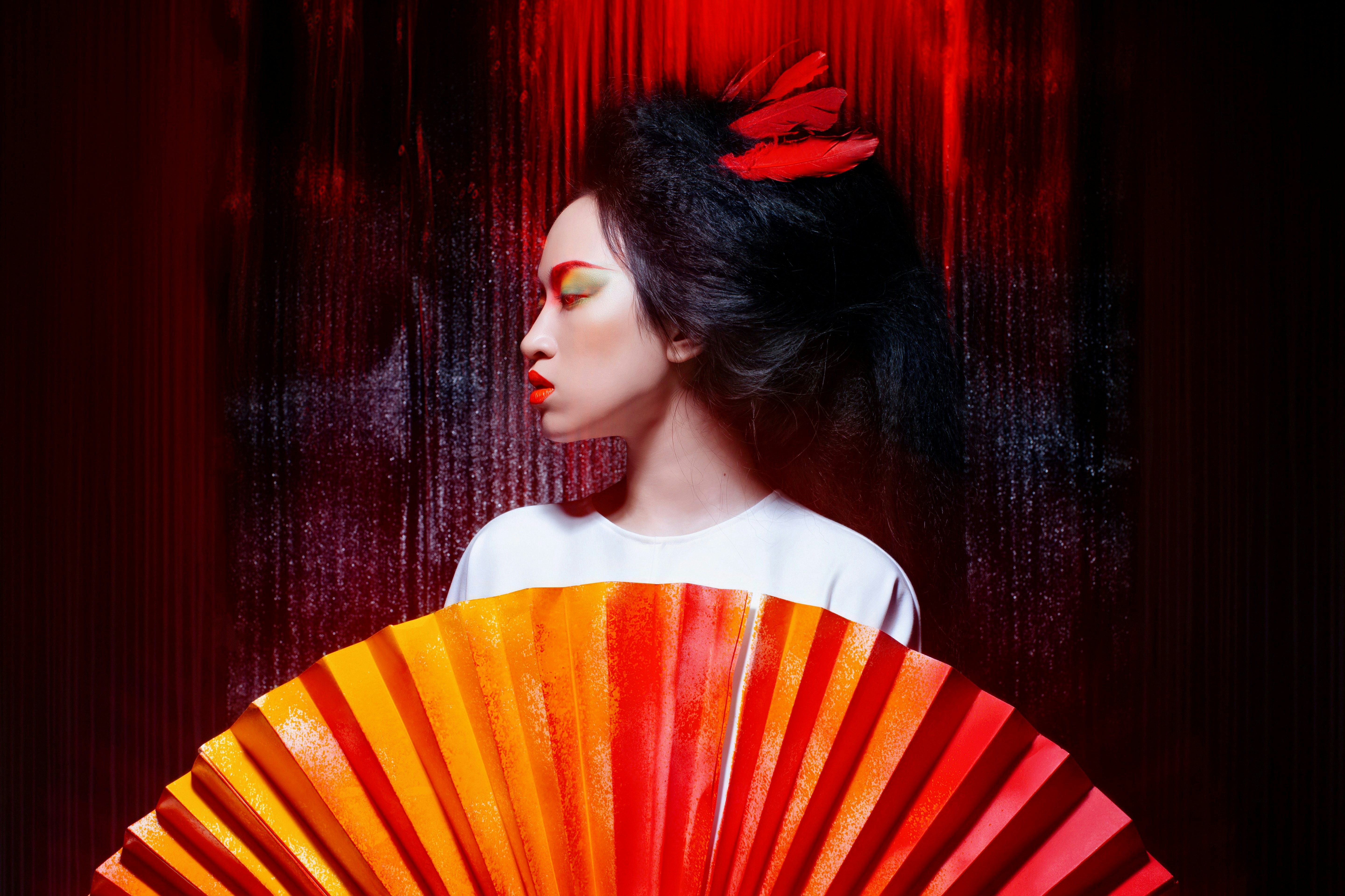Woman in traditional japanese attire with a large fan.