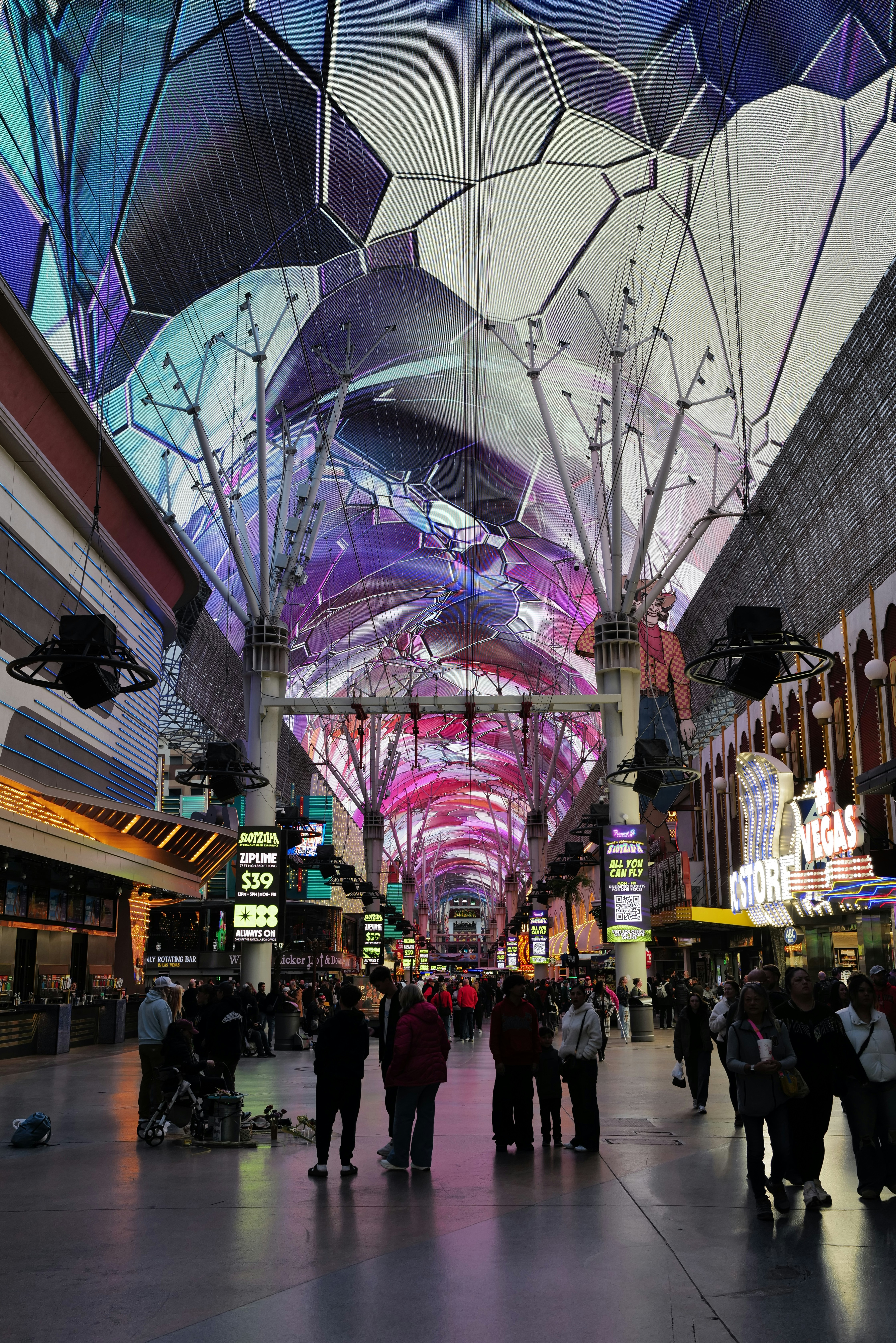 People walking under a vibrant, futuristic light canopy