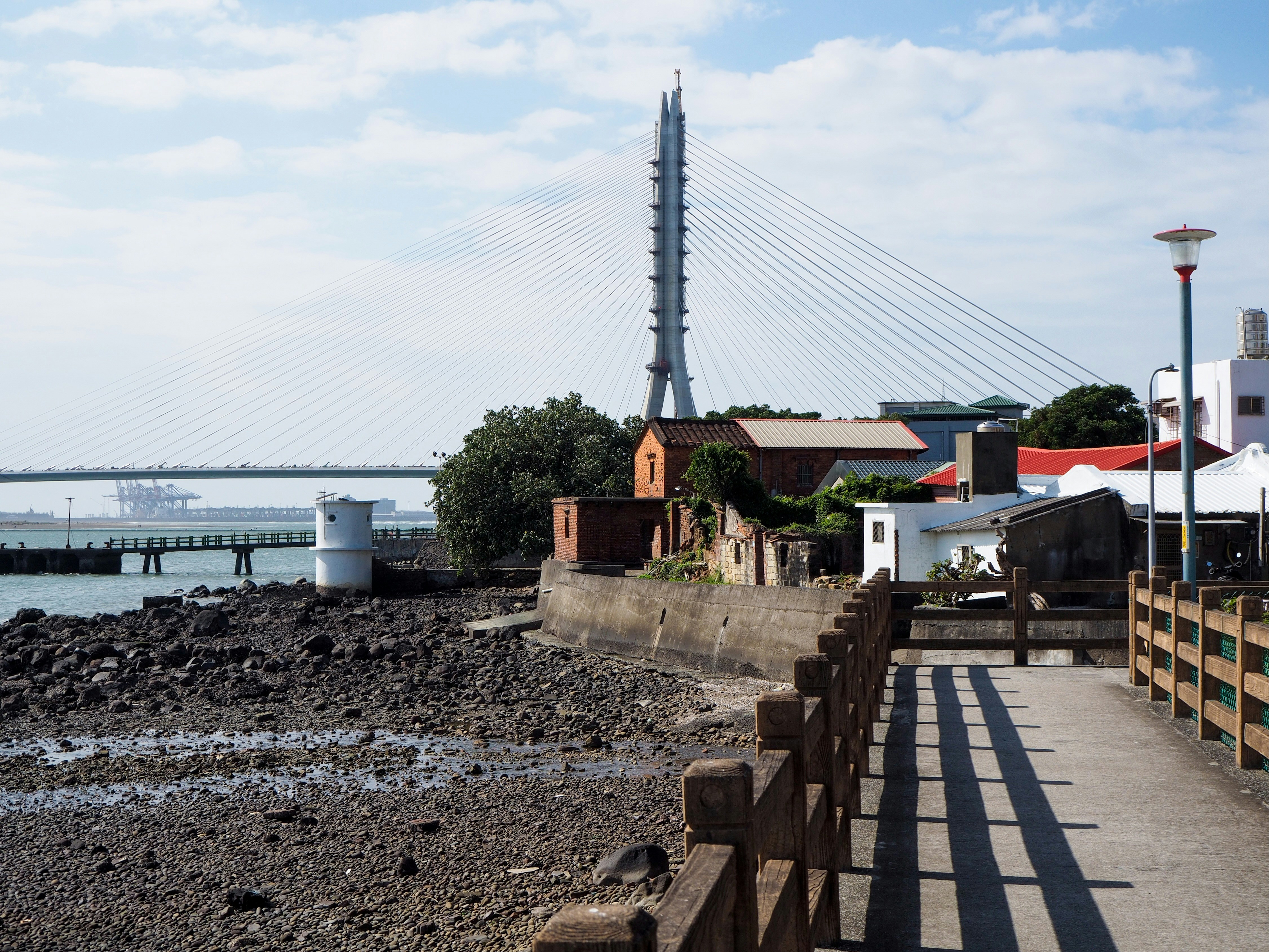 Coastal town with a bridge and lighthouse.