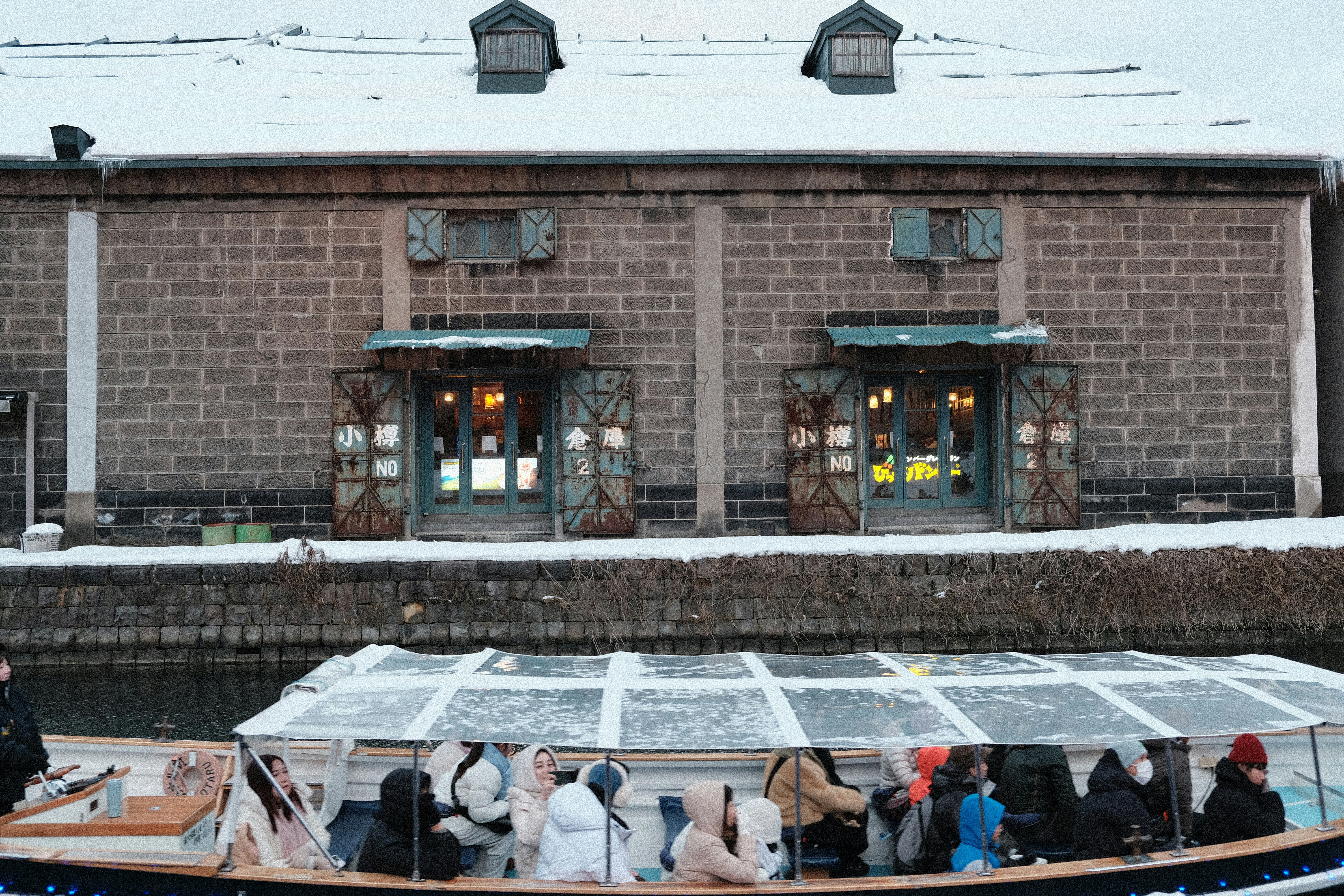 People on boat near brick building in snow