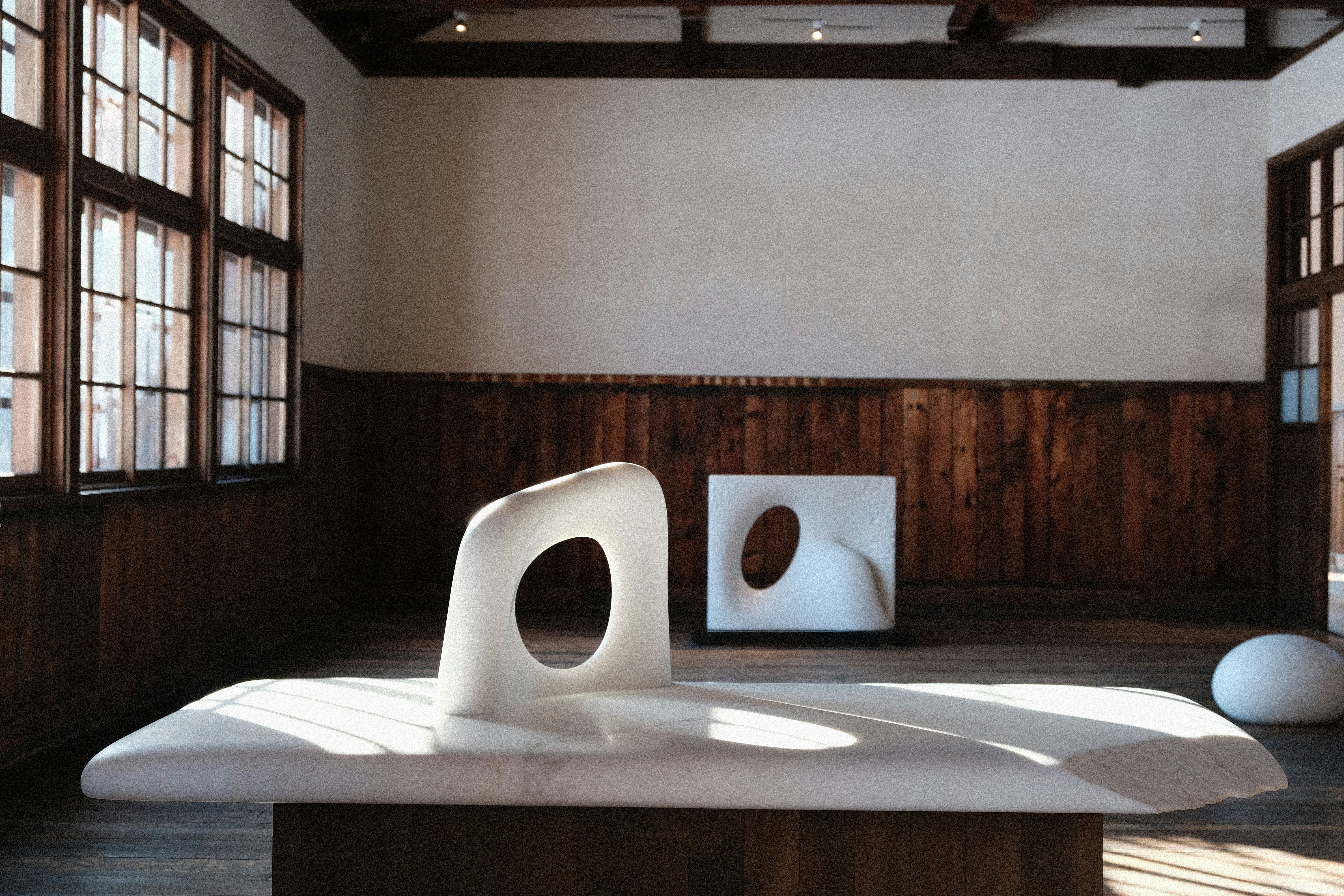 Modern sculptures in a minimalist exhibition space.