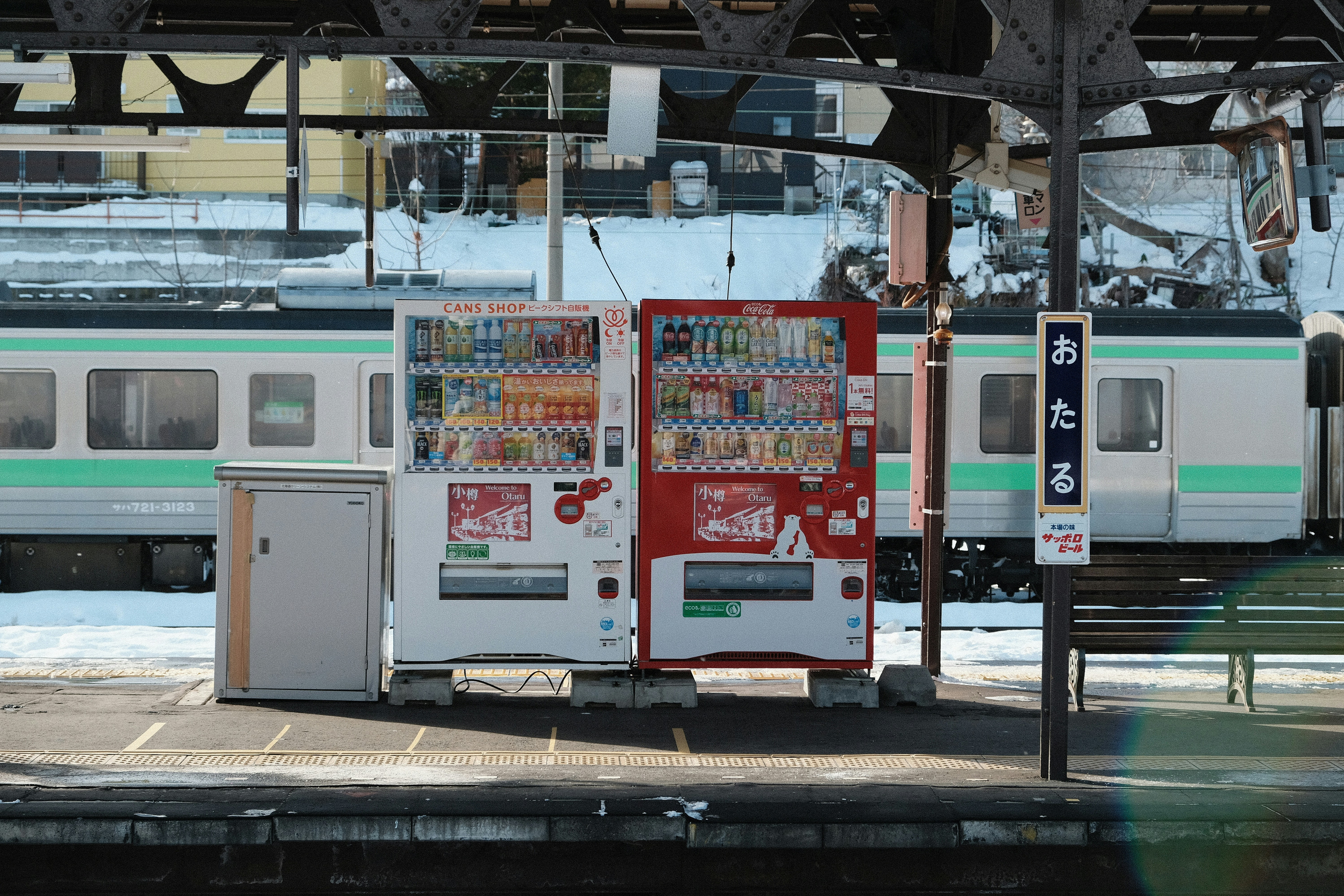 Two vending machines at a train station platform.