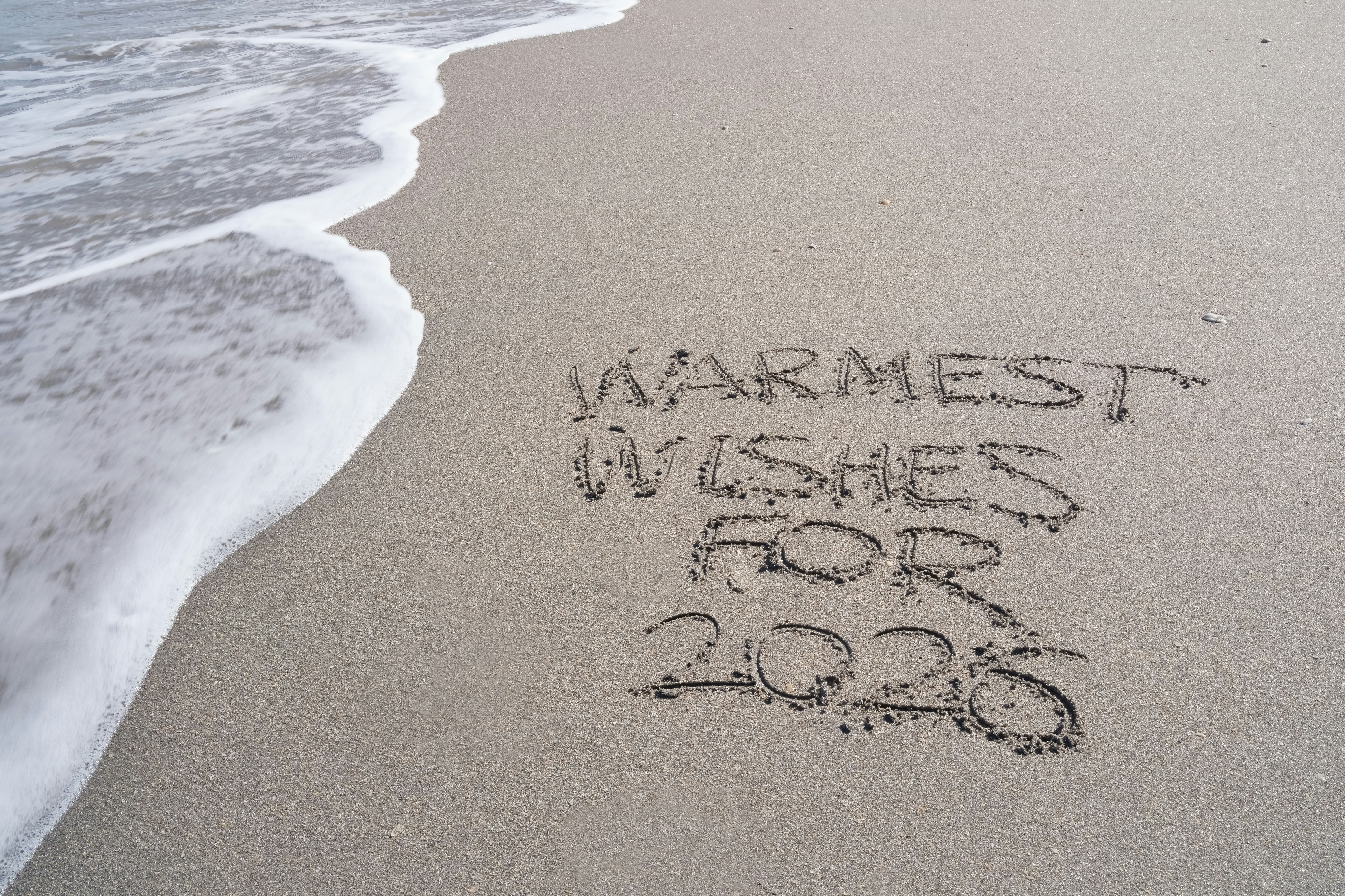 Warmest wishes for 2026 written in sand