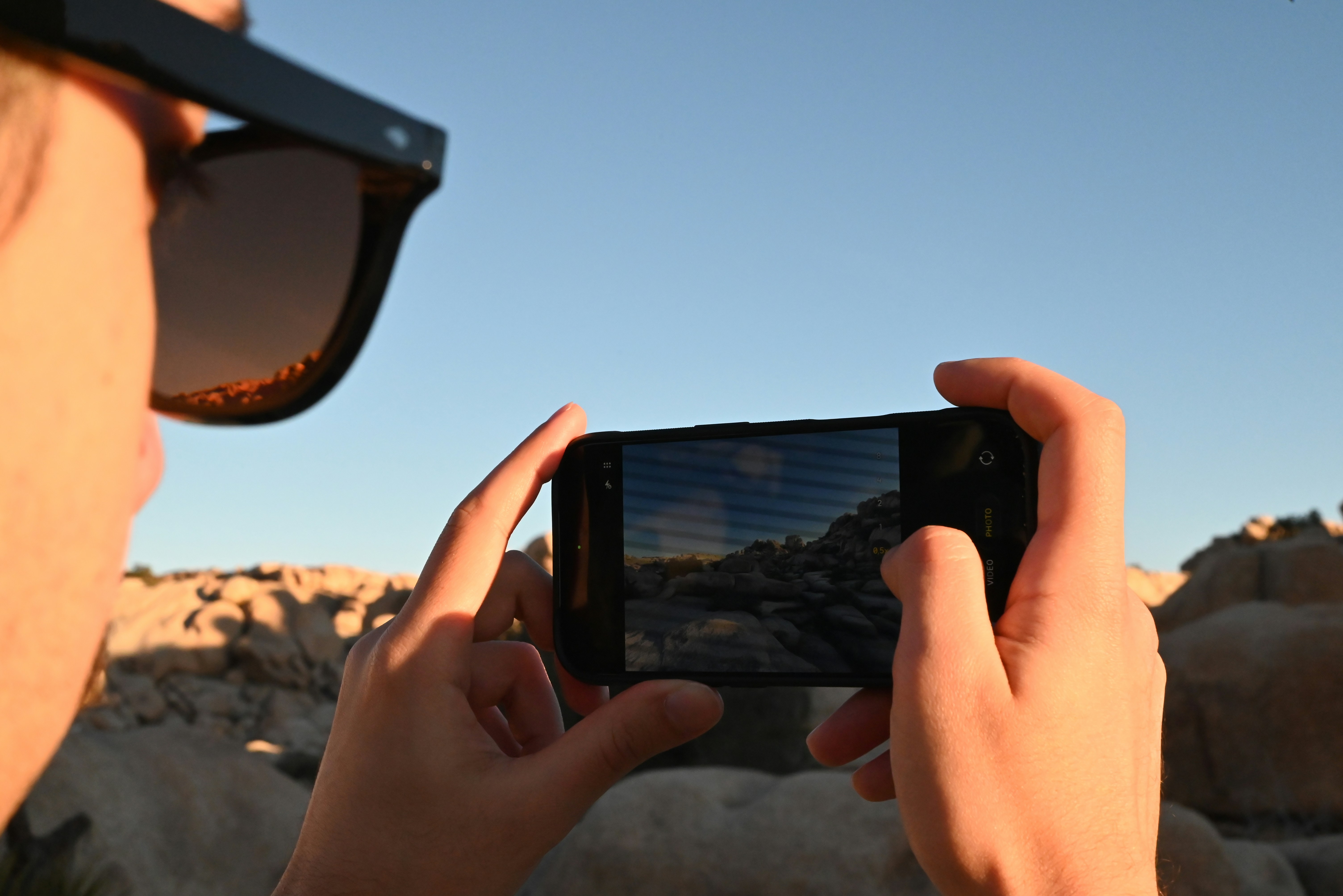 Person taking a picture of a rocky landscape