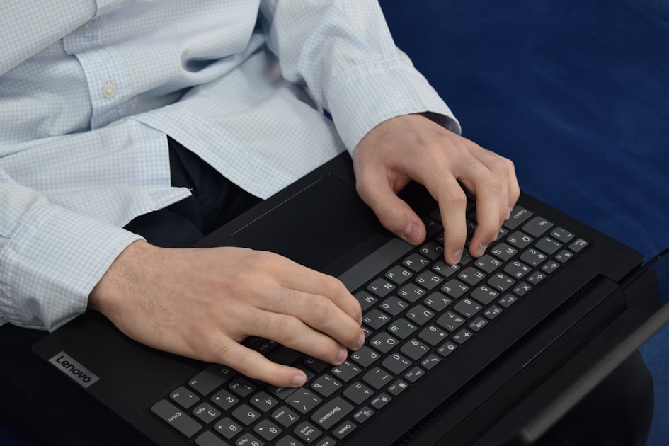 Close-up of hands typing on a laptop keyboard filling out a contact form