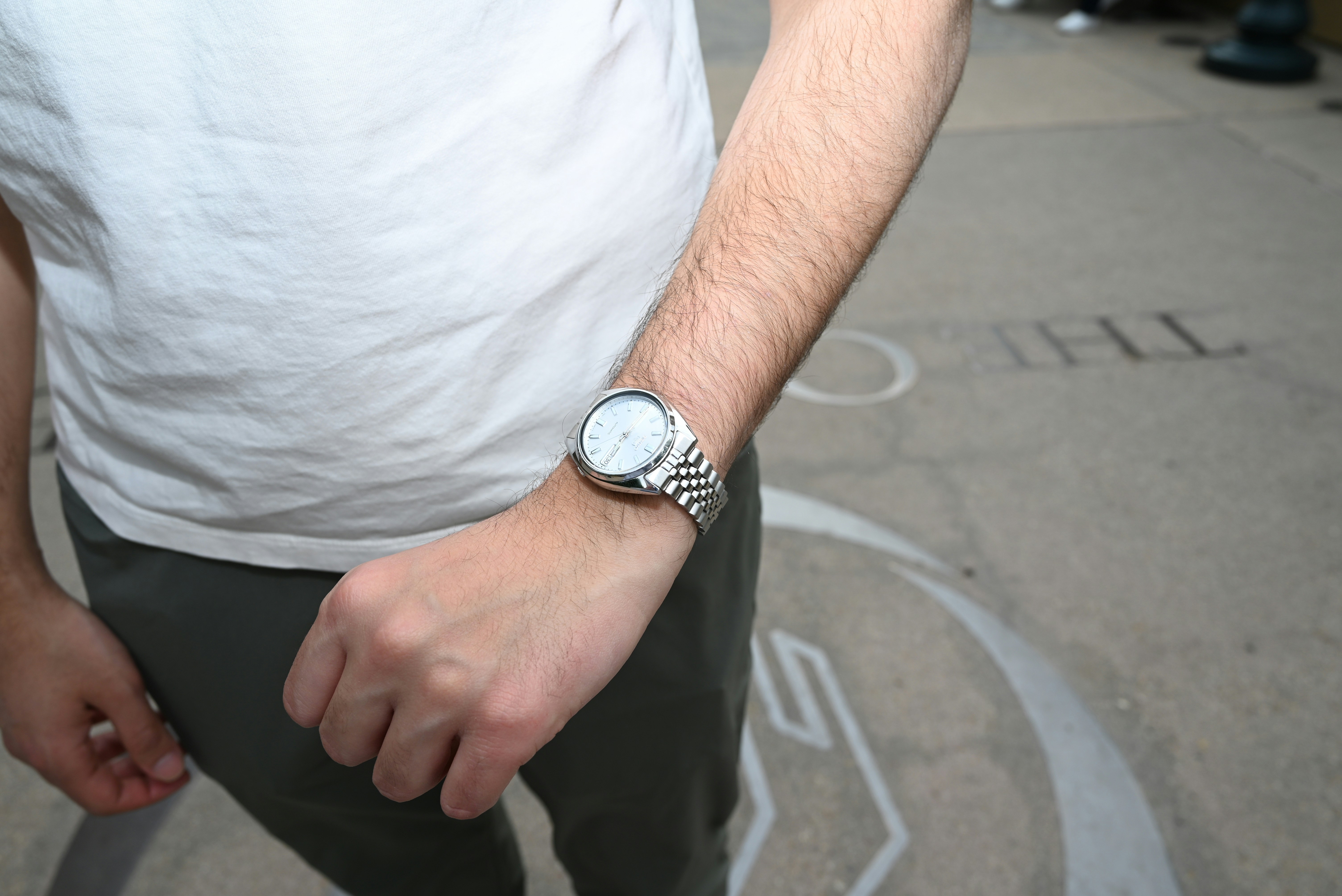 Man wearing a silver wristwatch on his arm