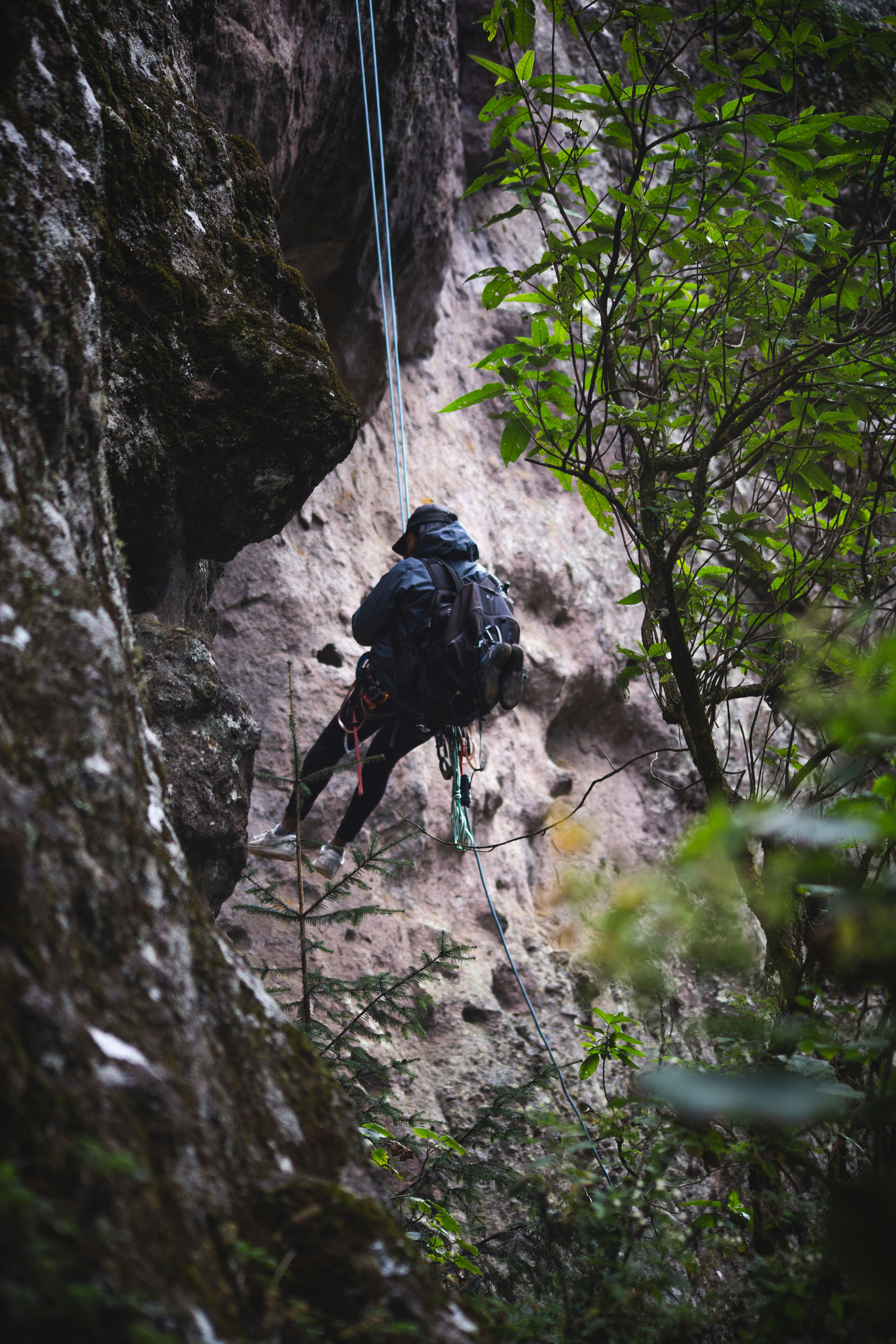 Person rappelling down a rocky cliff face