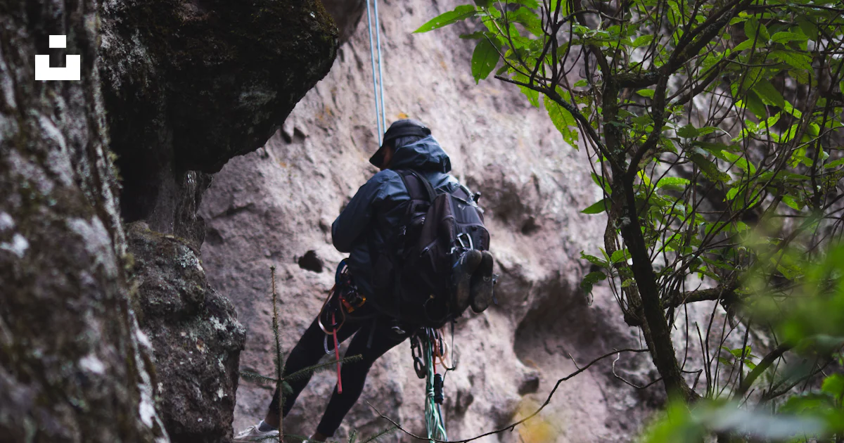 Person rappelling down a rocky cliff face photo – Free Challenge Image ...
