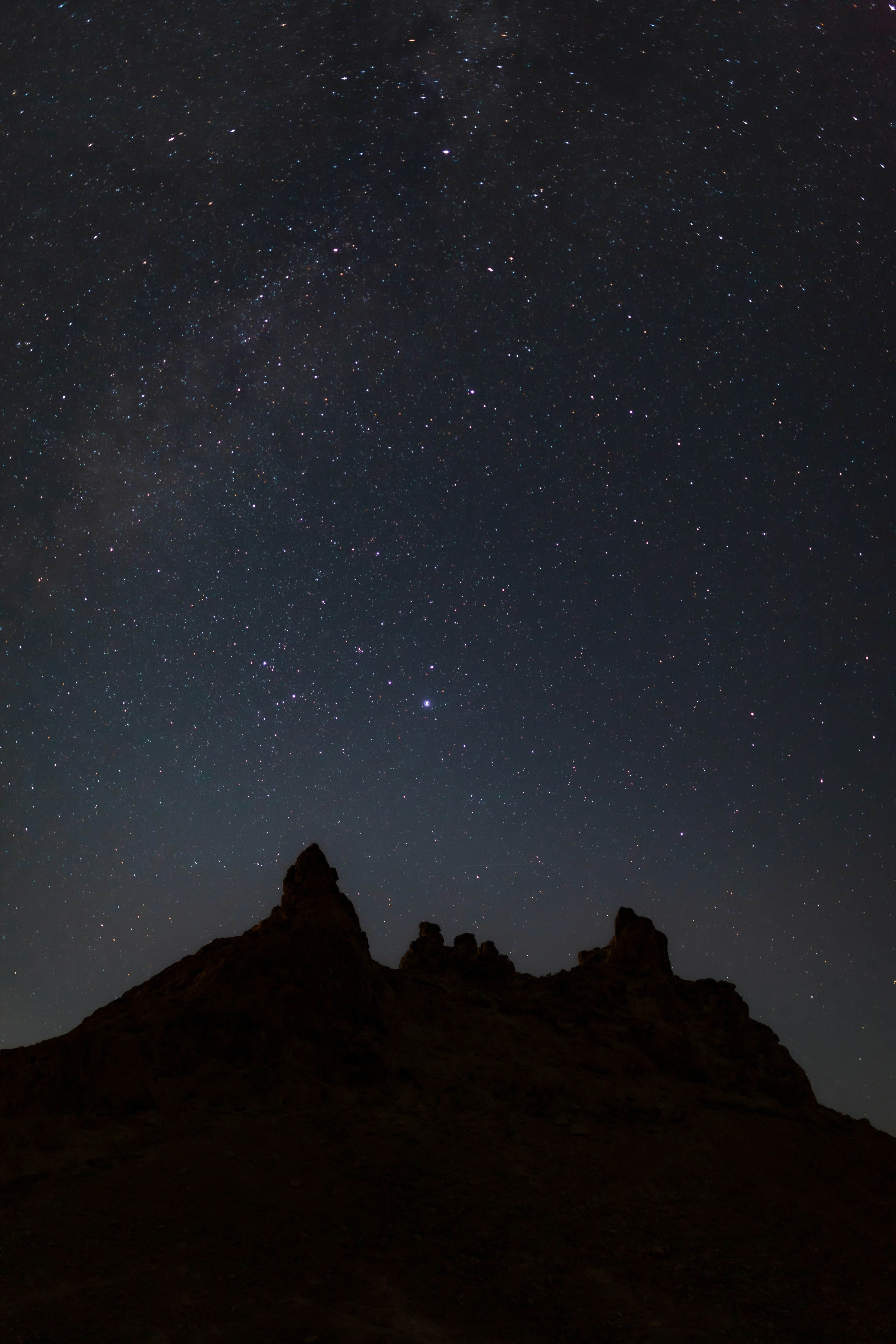 Silhouette of jagged mountains under a starry night sky.