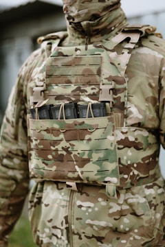 Soldier in camouflage uniform with tactical vest.