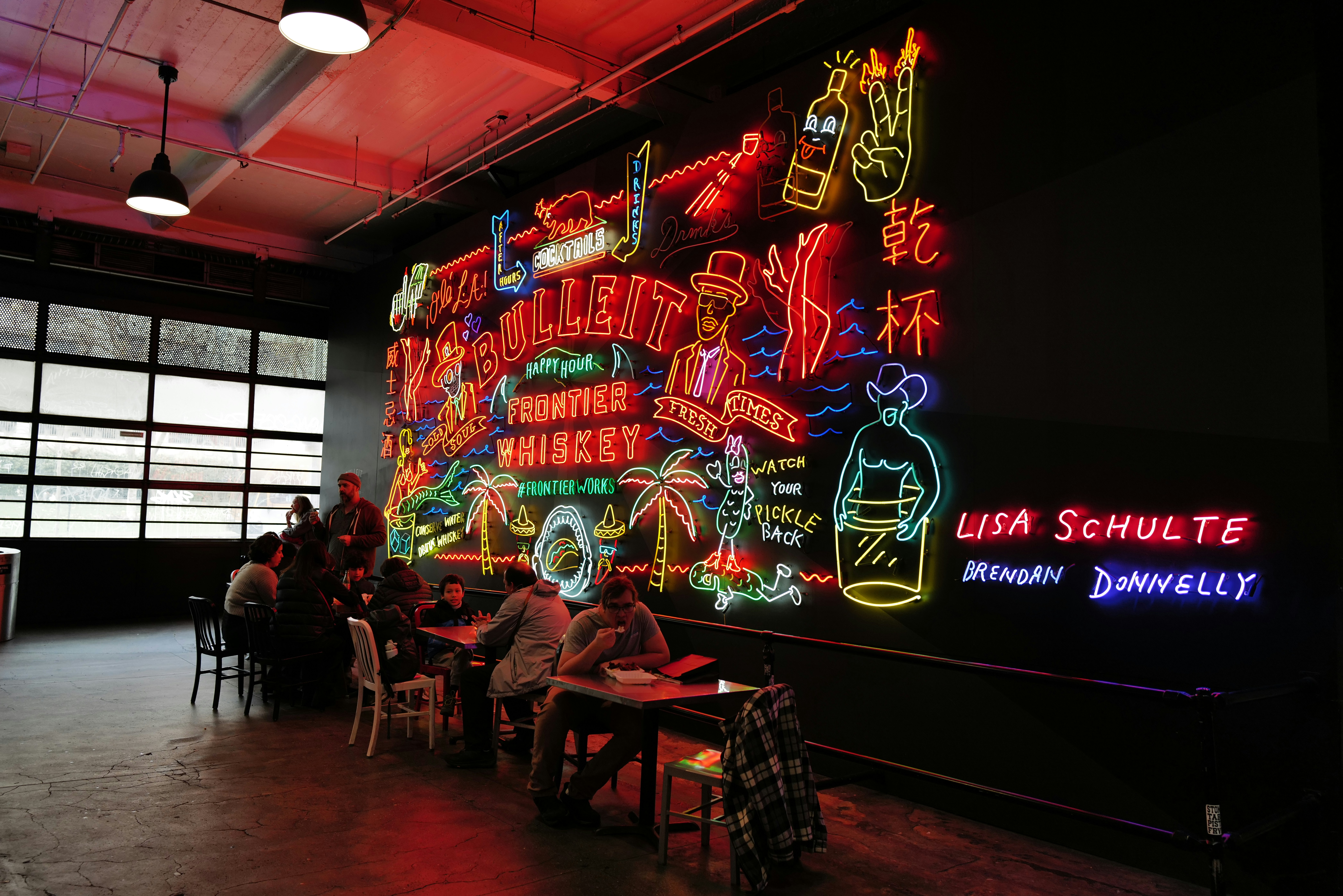 Colorful neon sign art installation with people