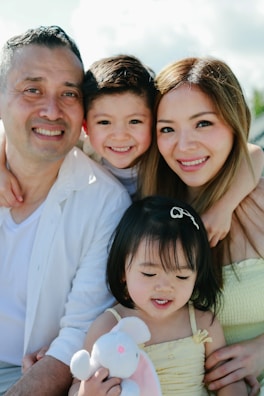 Happy family of four smiling together outdoors
