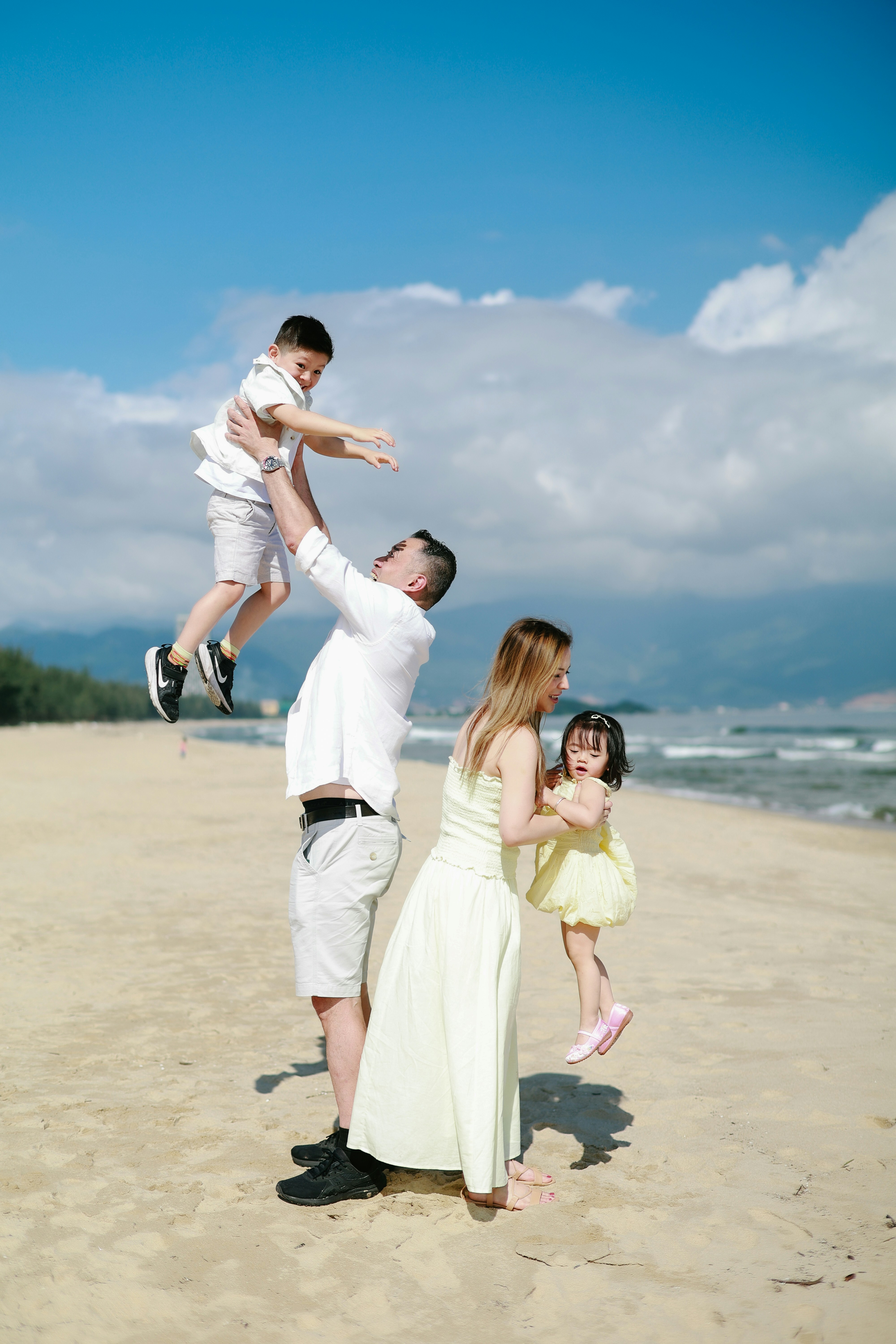 Family playing on a sunny beach day.