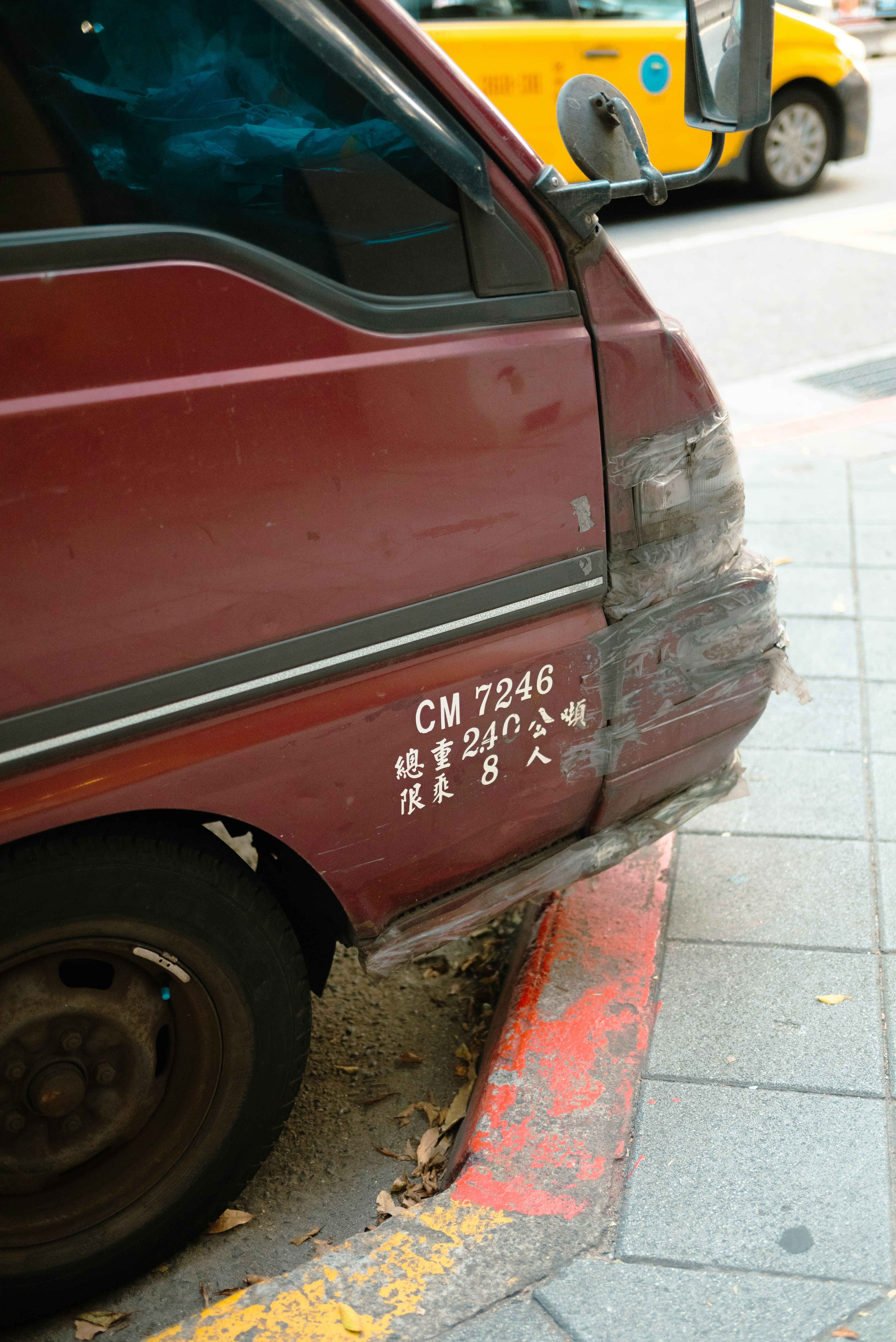 Maroon van with chinese text parked by curb