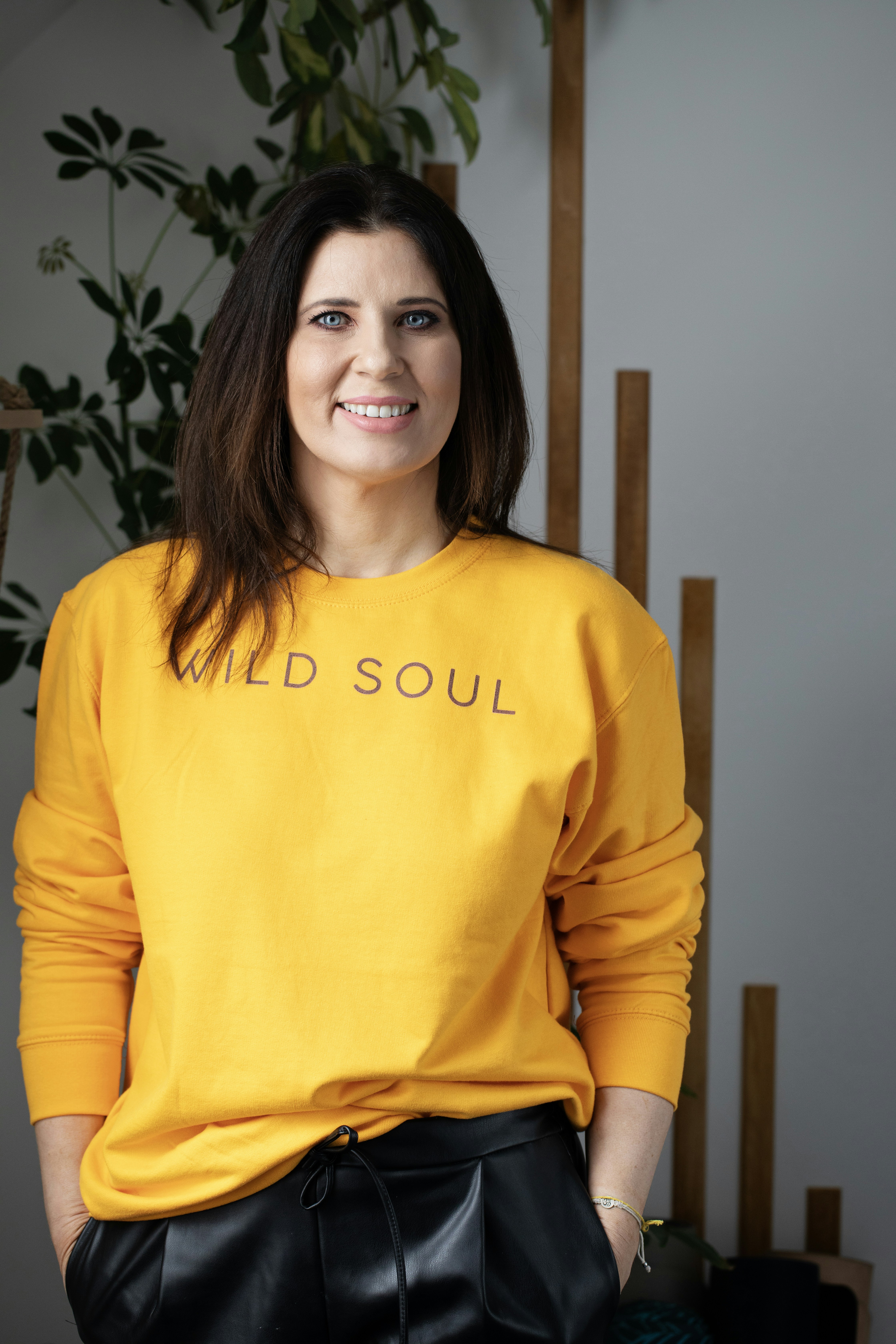 Woman in yellow sweatshirt with text "wild soul"