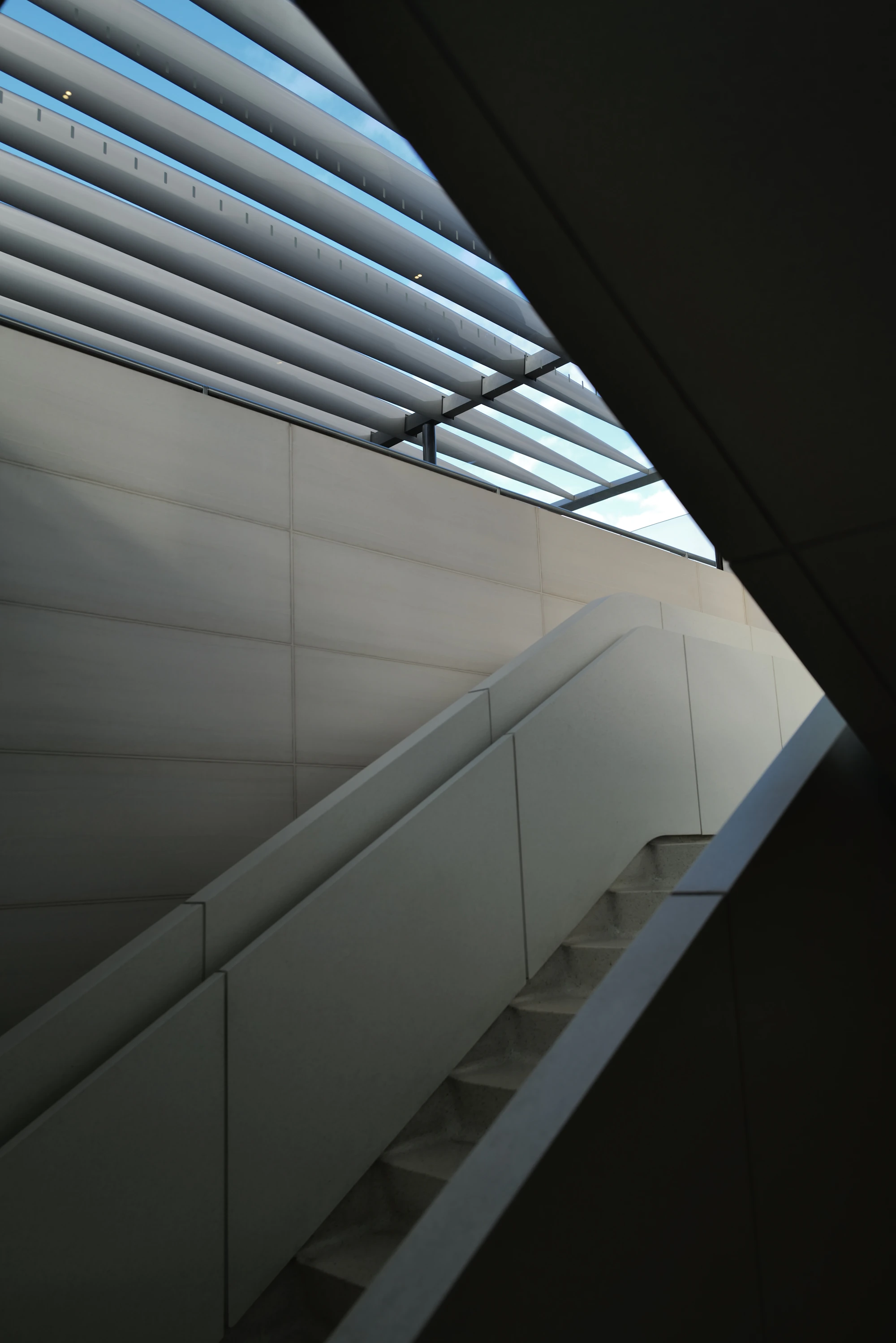 Modern architectural staircase rising beneath a blue sky