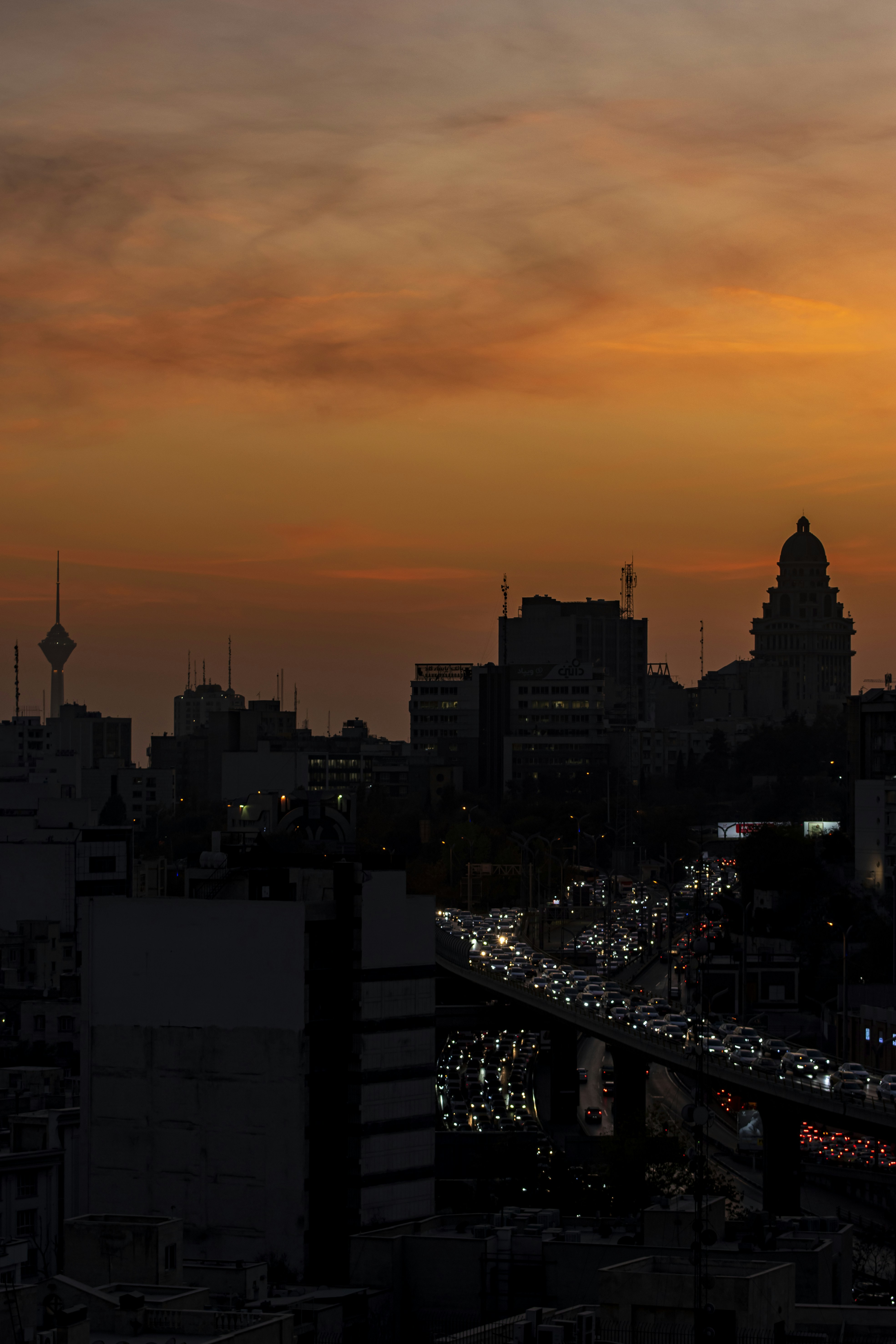 Horizonte urbano al anochecer con tráfico en la autopista.