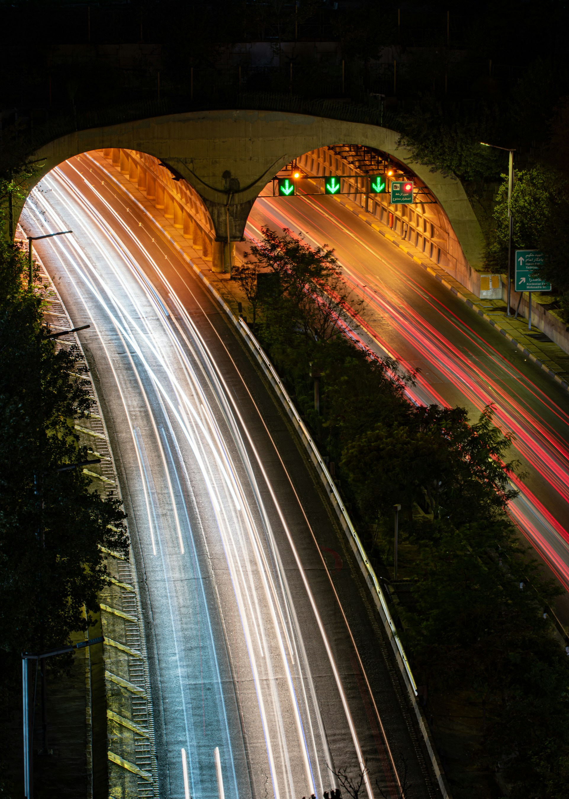 Estelas de luz de coches que entran en un túnel por la noche.