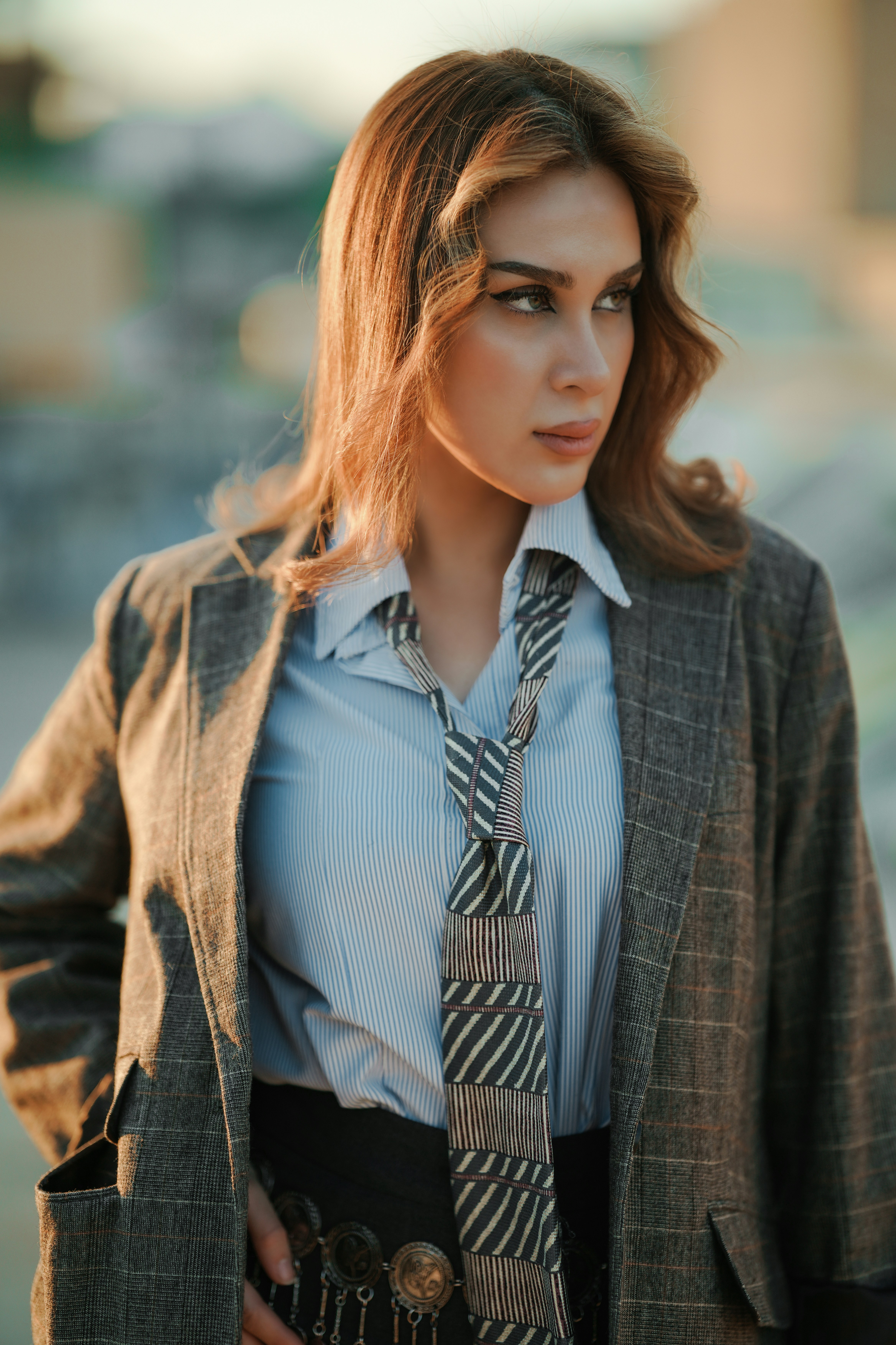 A woman wearing a blazer and tie outdoors